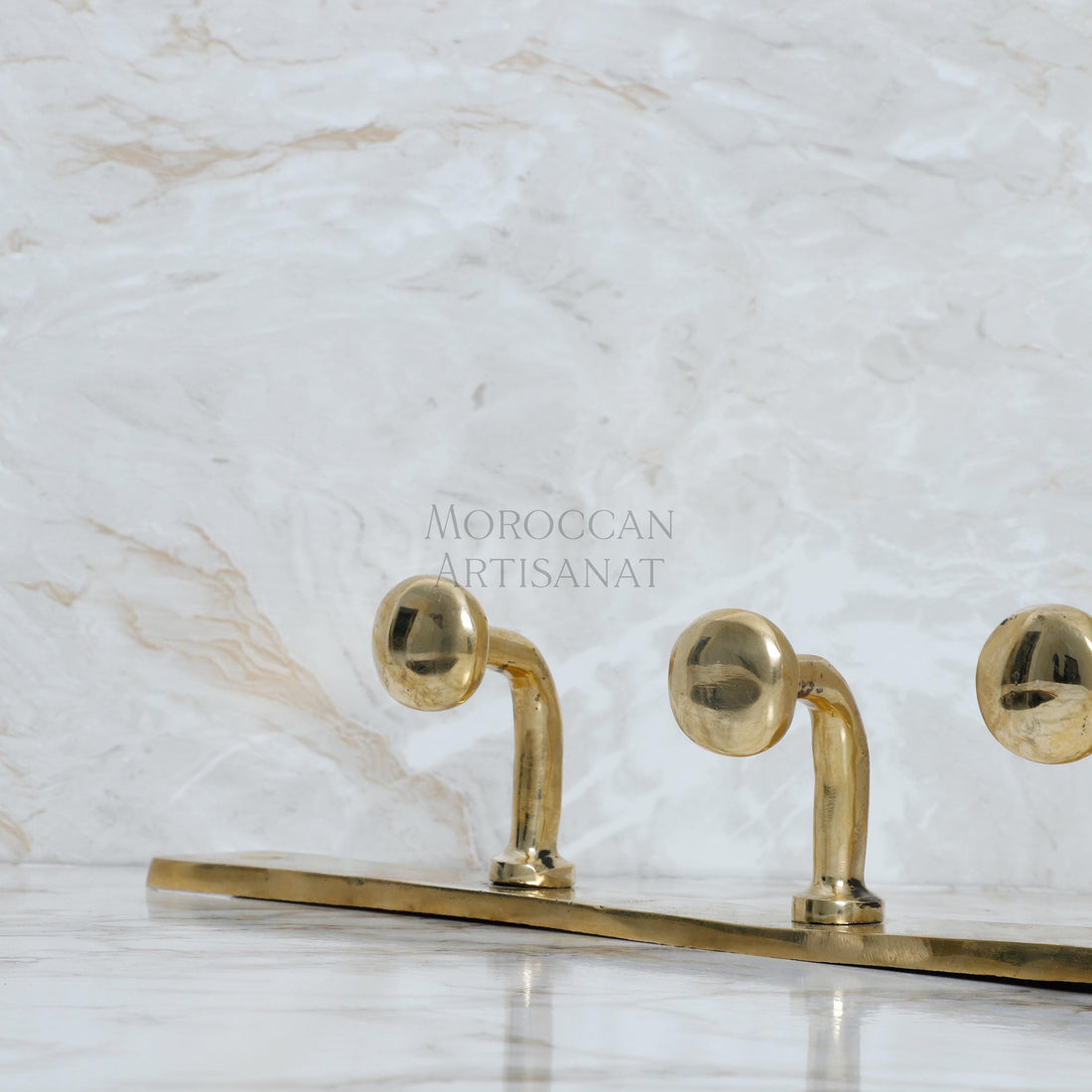 a pair of brass candlesticks on a marble surface