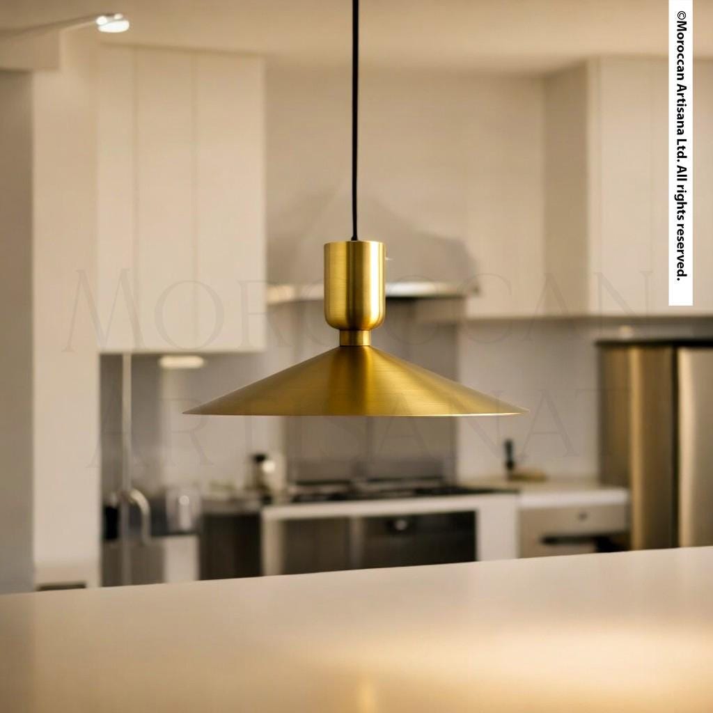 A modern kitchen with a gold pendant light hanging above a countertop.