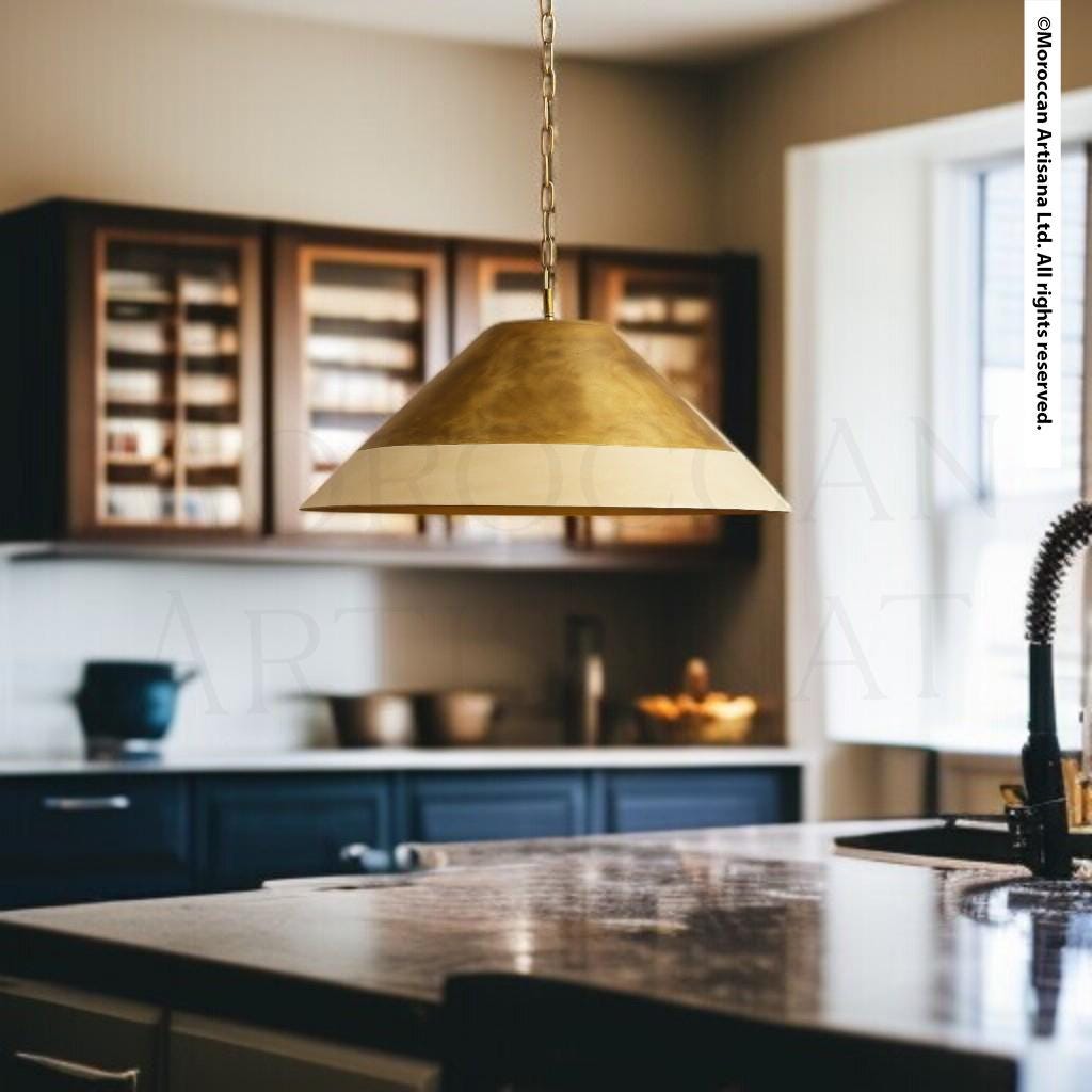 a modern kitchen with a gold pendant light hanging above a marble countertop.