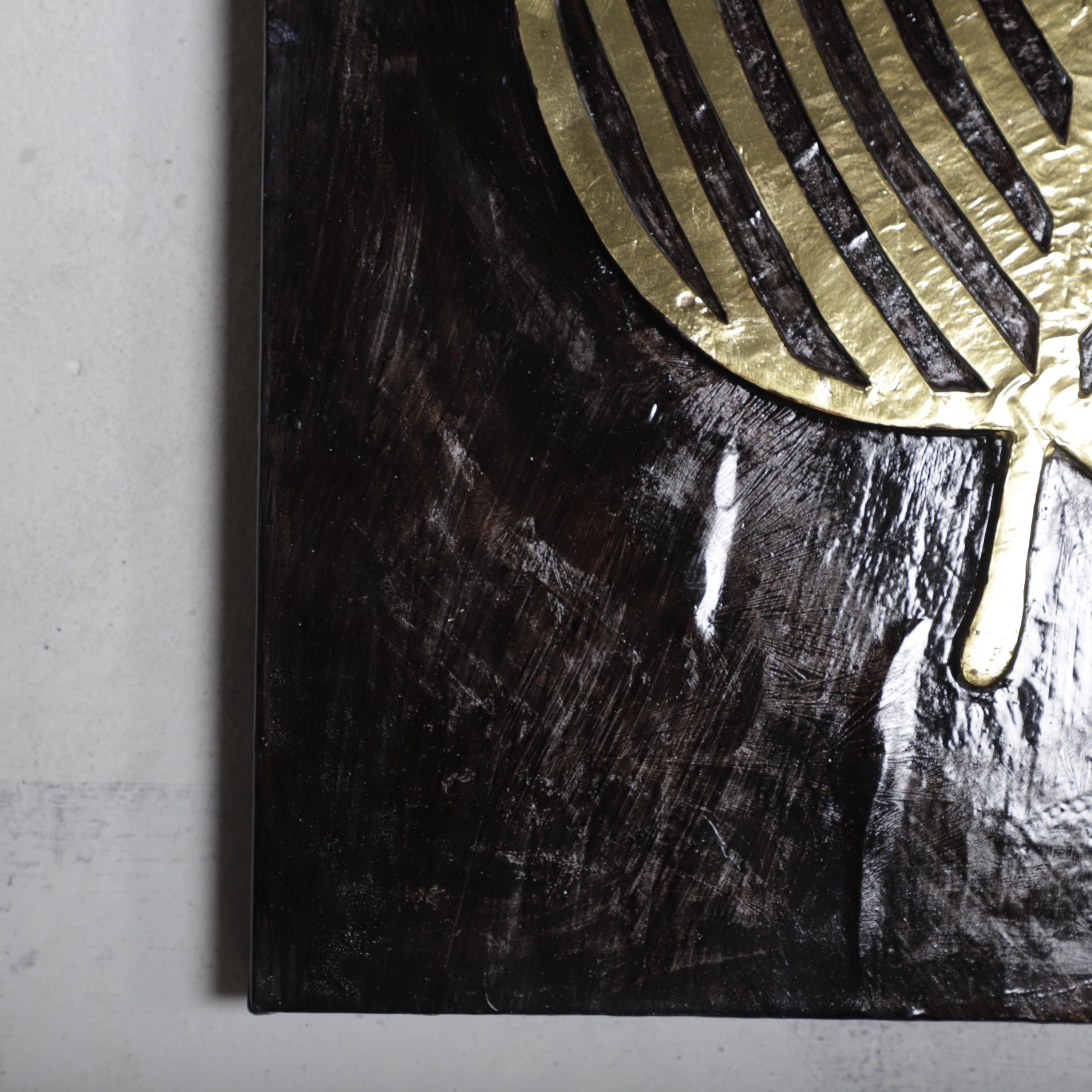 The image is a close-up of a dark, textured surface with a gold-colored, striped pattern.