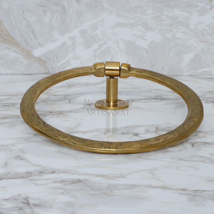 a brass towel ring on a marble counter
