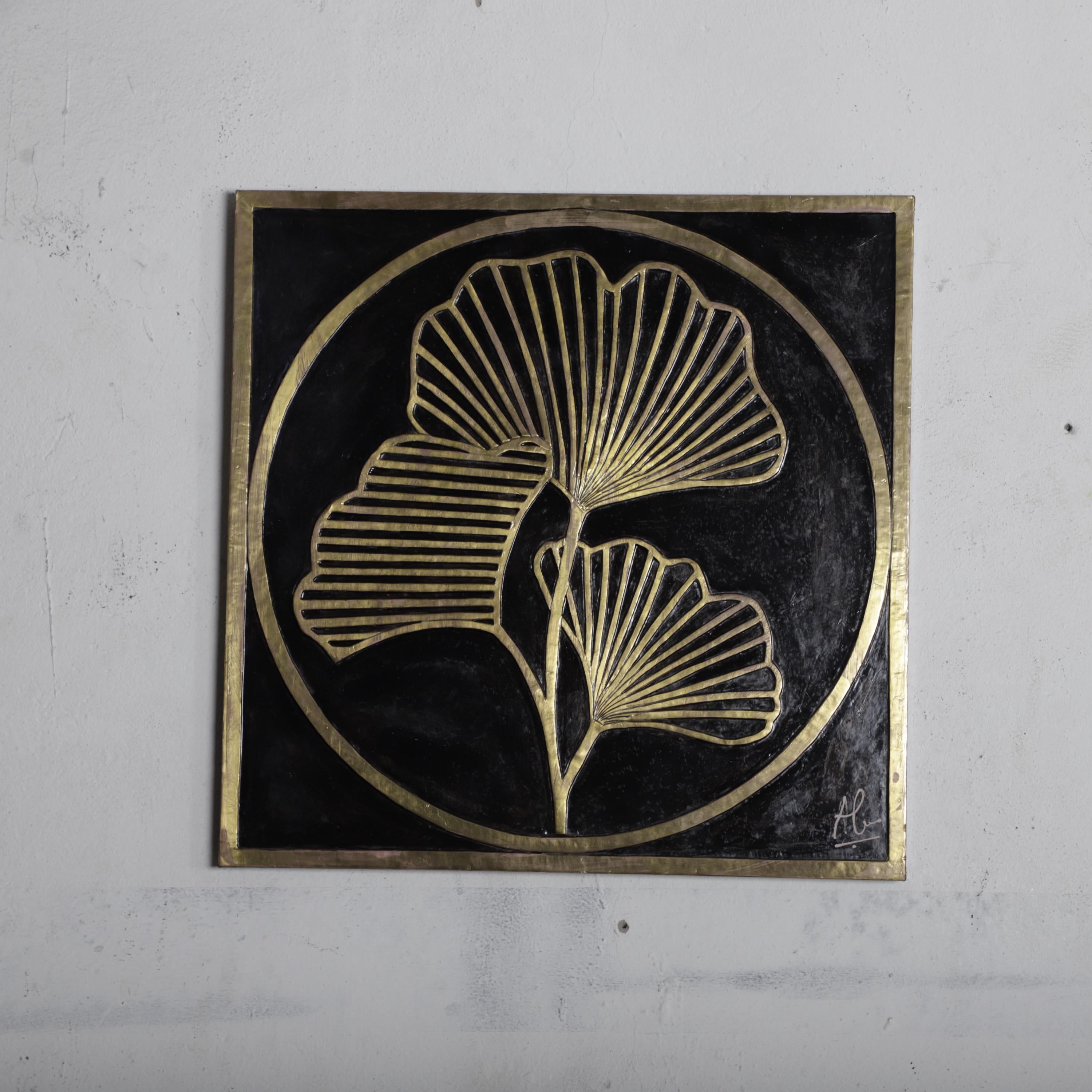a square-shaped artwork with a black background and gold leaf-like patterns.