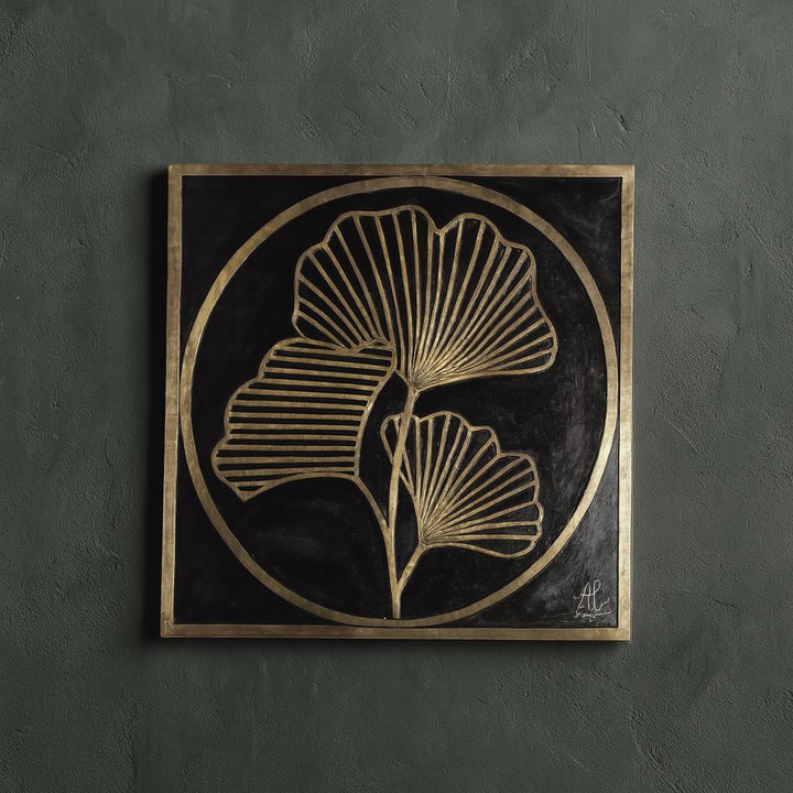a square-shaped artwork with a black background and a gold border. The artwork displays a stylized design of two stylized leaves or flowers, with intricate patterns and lines.