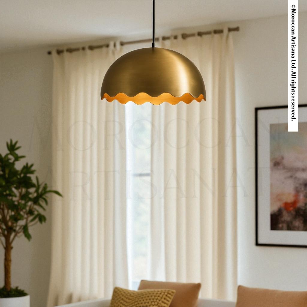 a modern living room with a gold-colored pendant light hanging from the ceiling, casting a warm glow. The room is decorated with a white sofa, a plant, and a framed artwork on the wall.