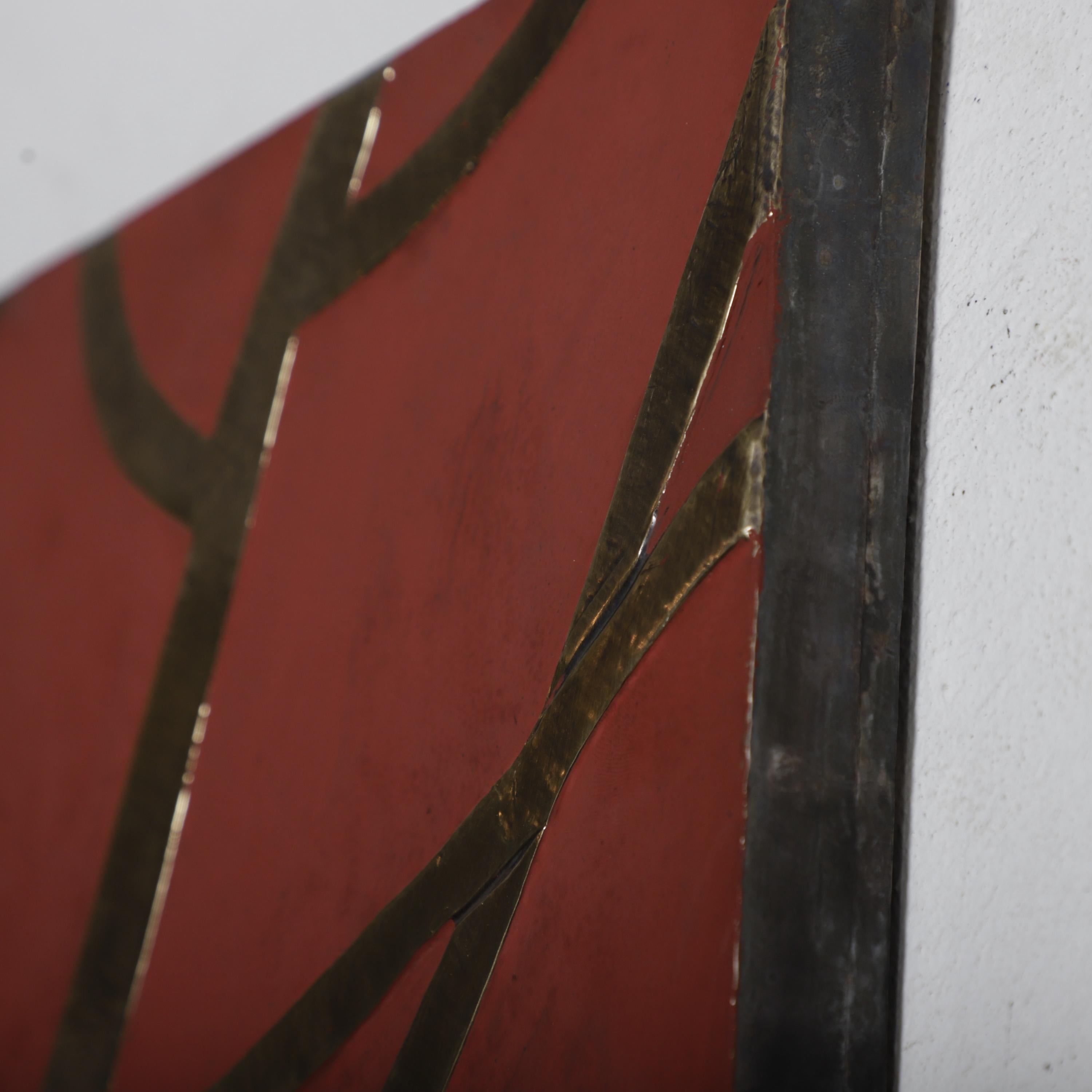 a close-up view of a red surface with a metallic, intersecting line design.