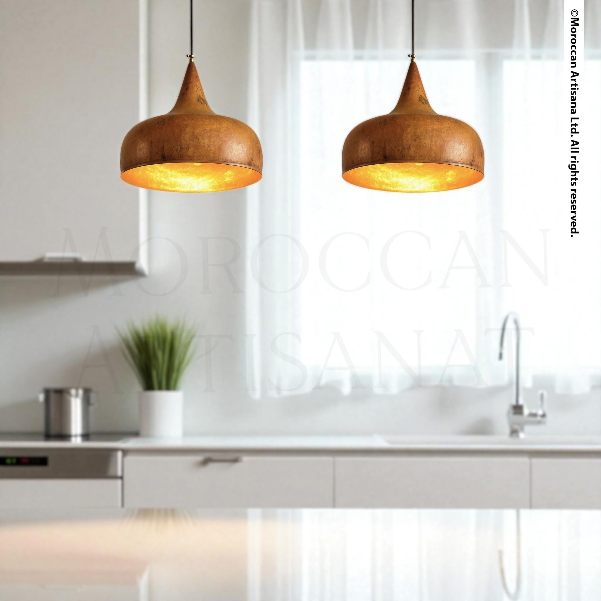 a modern kitchen with a pair of hanging pendant lights, a stainless steel sink, and a white countertop.