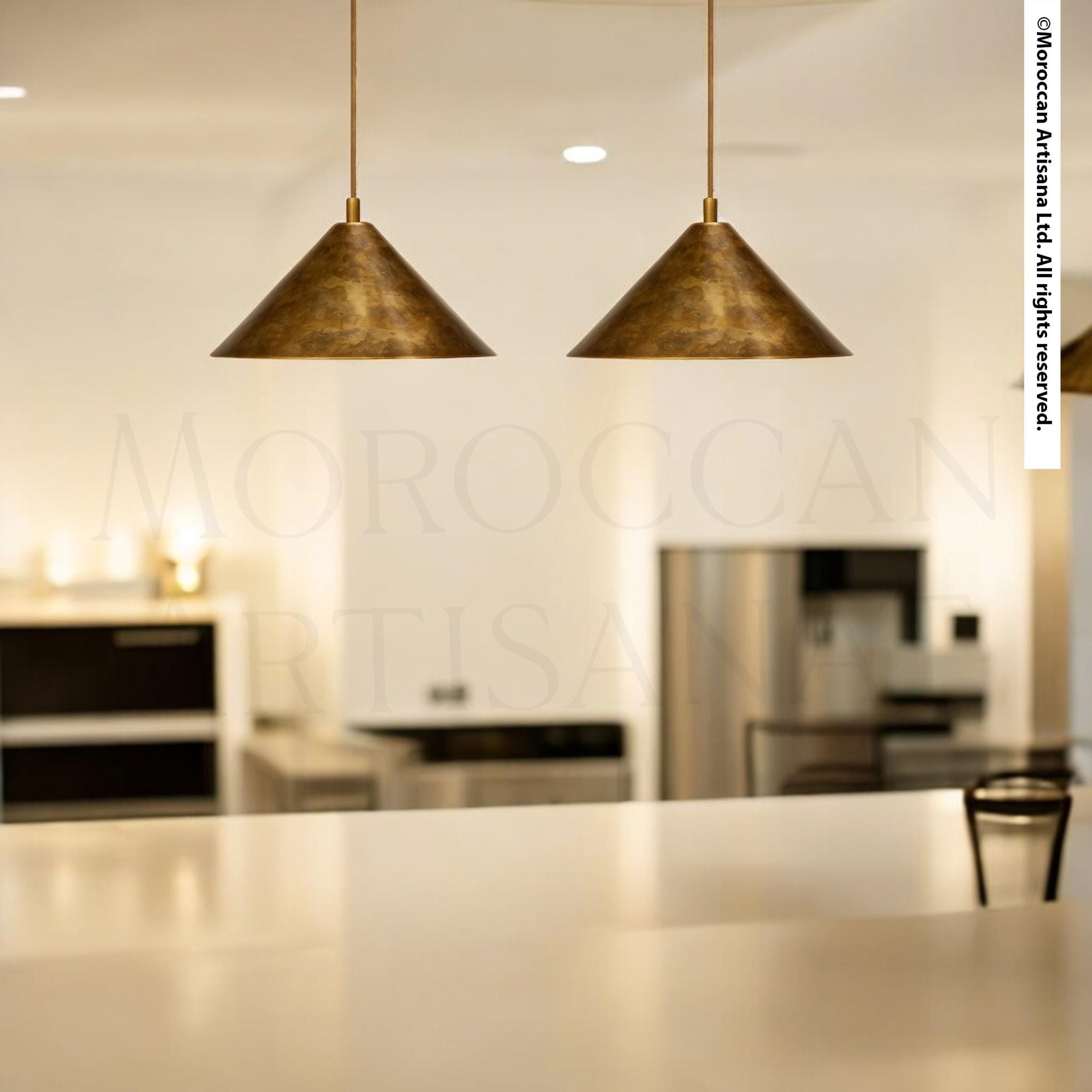 a modern kitchen with two pendant lights hanging above a white countertop.