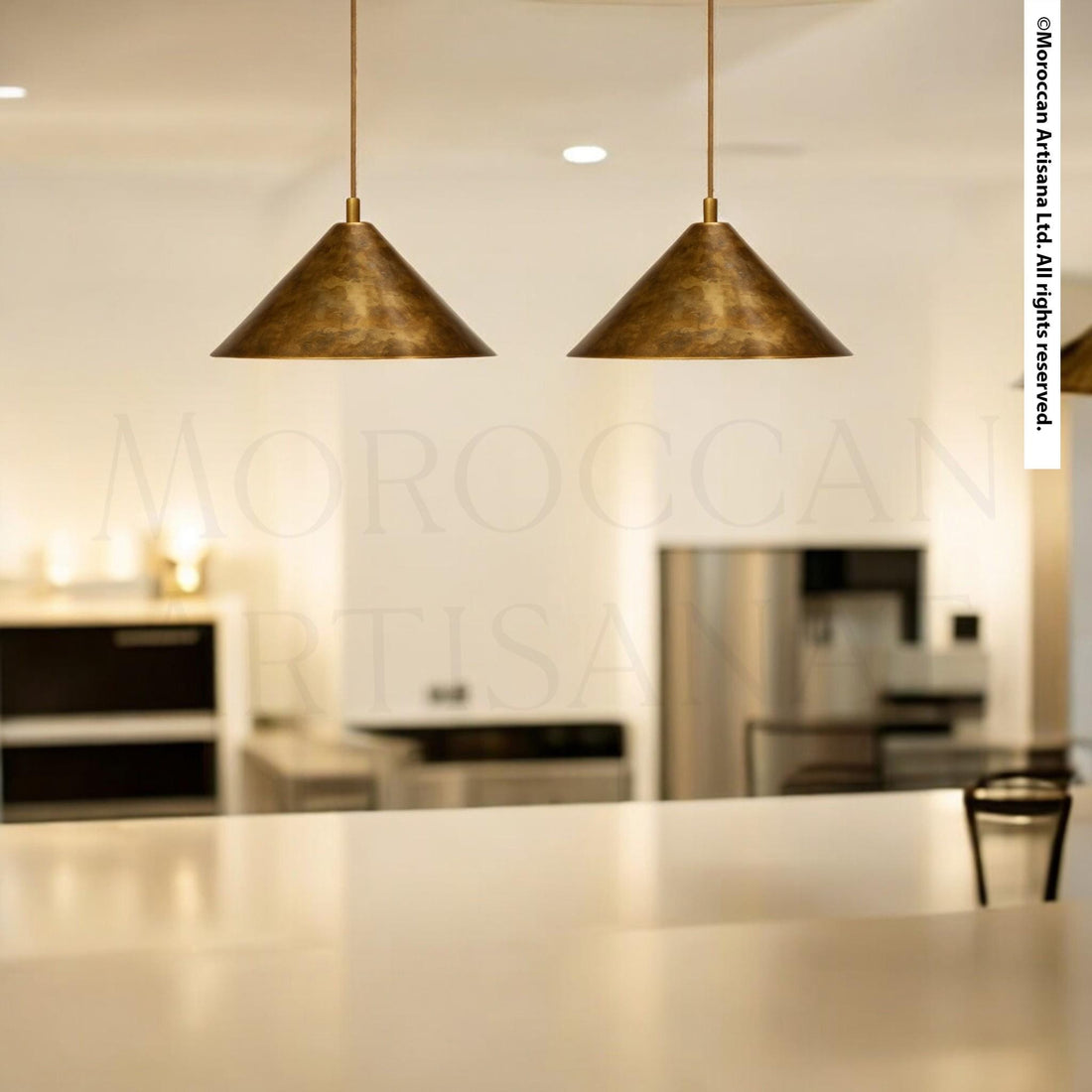 a modern kitchen with two pendant lights hanging above a white countertop.