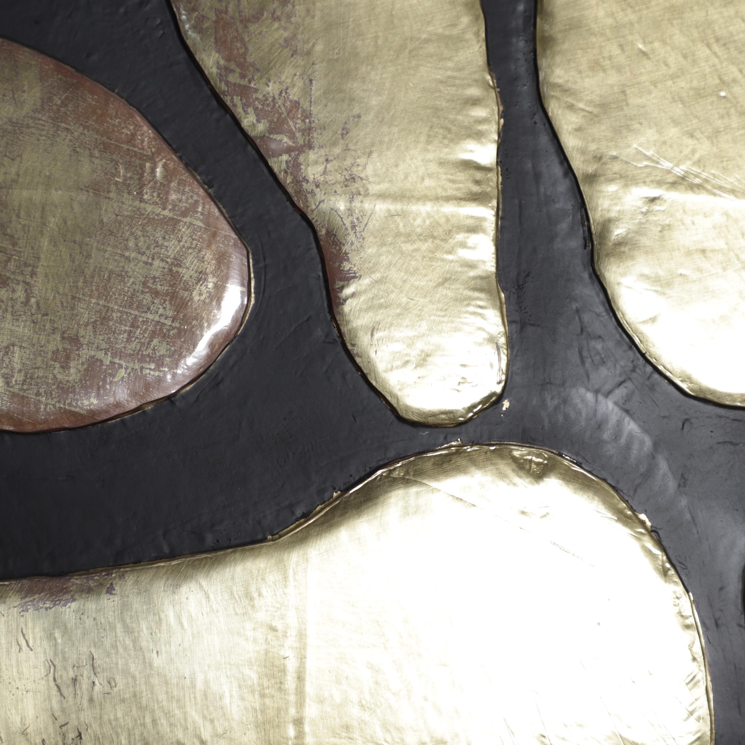 The image is a close-up of a textured surface with a combination of gold and black elements. The gold elements appear to be metallic and have a shiny, reflective appearance, while the black elements have a matte, textured finish. The overall composition creates a visually interesting contrast between the two contrasting textures.