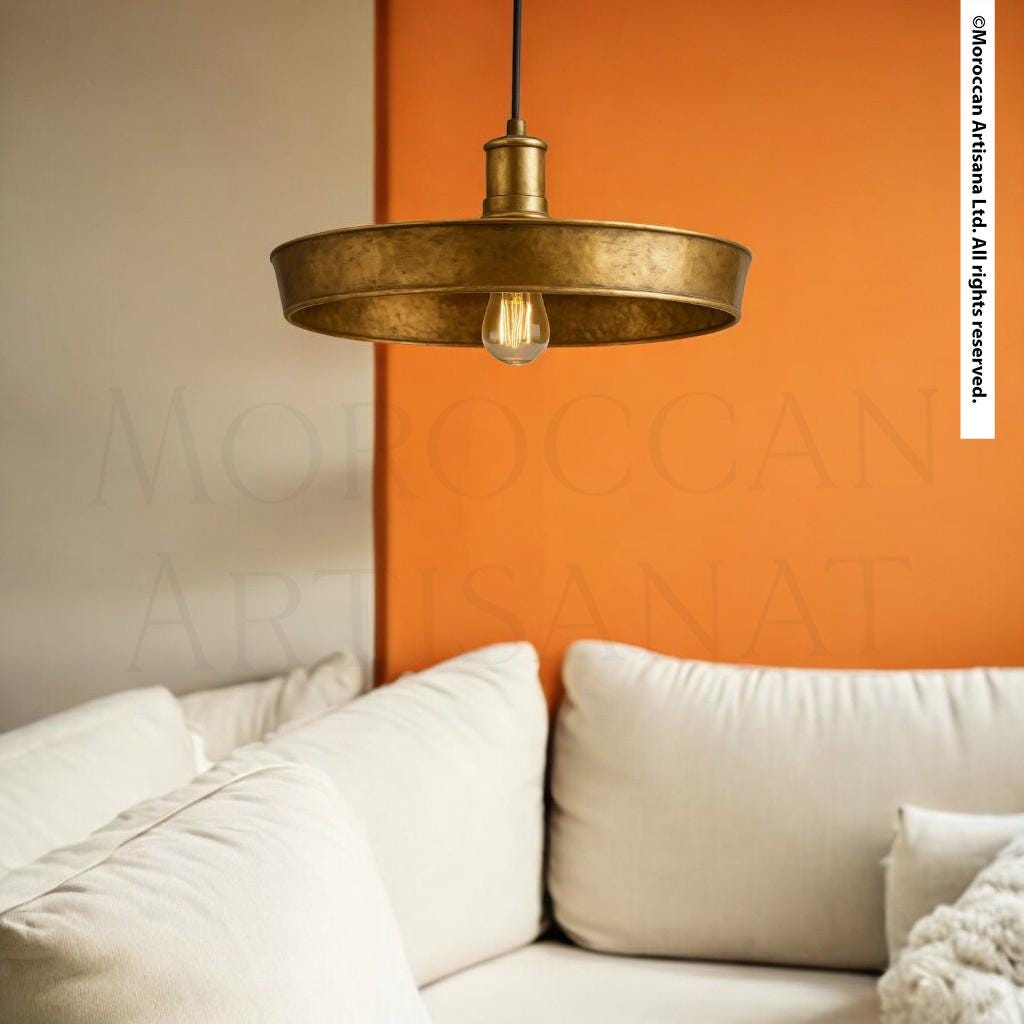 a modern living room with a white sofa and a gold pendant light hanging above it.
