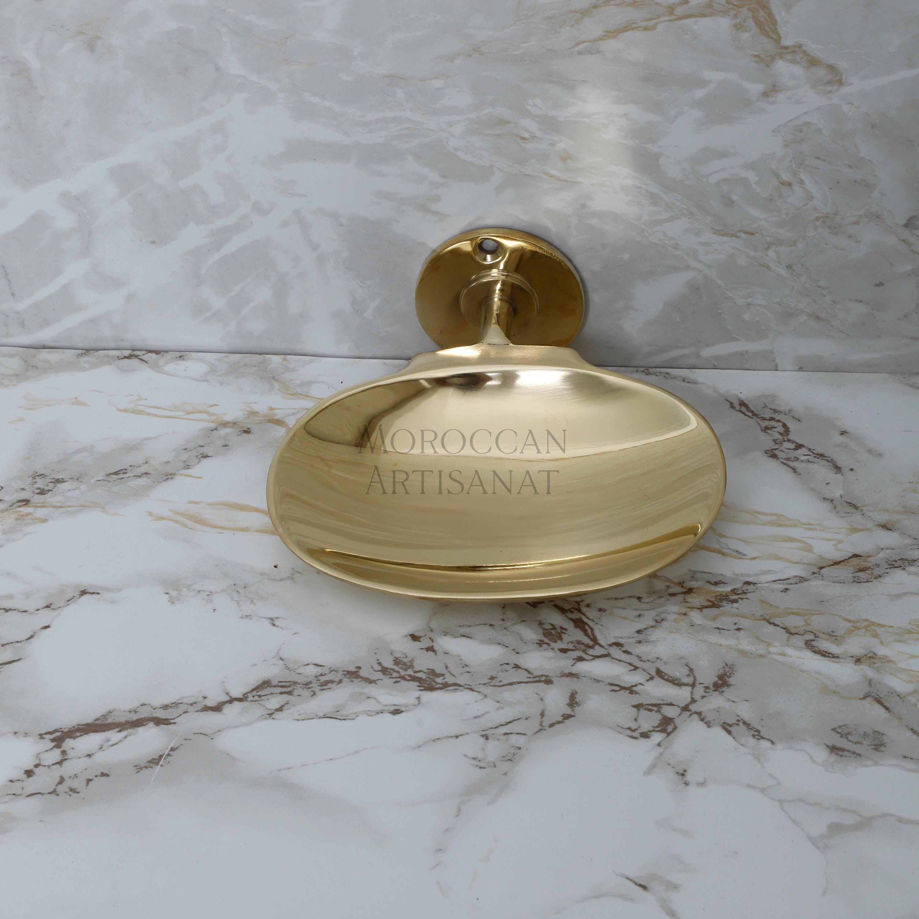 a golden soap dispenser sitting on a marble counter