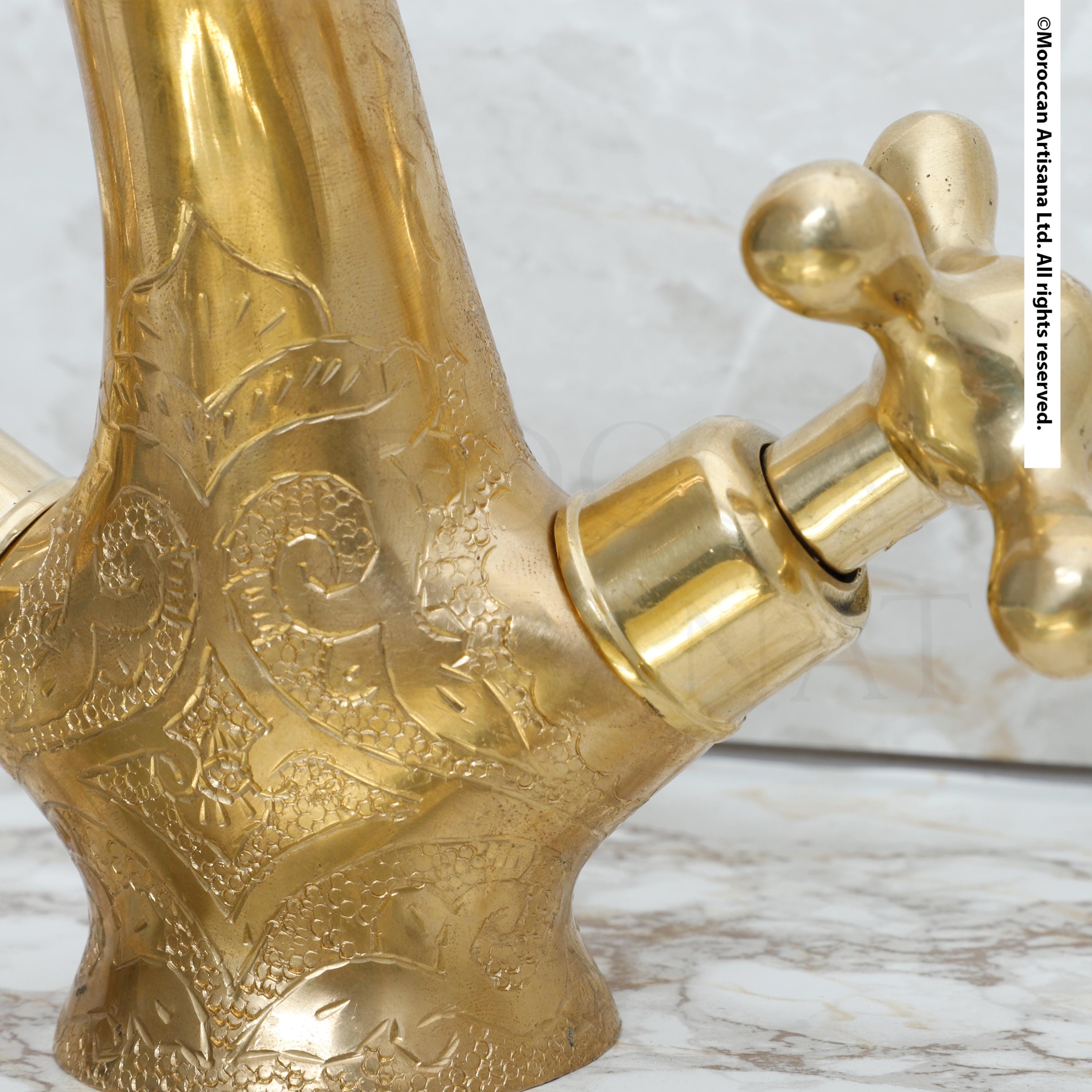A close-up view of a decorative brass faucet with intricate patterns and designs.