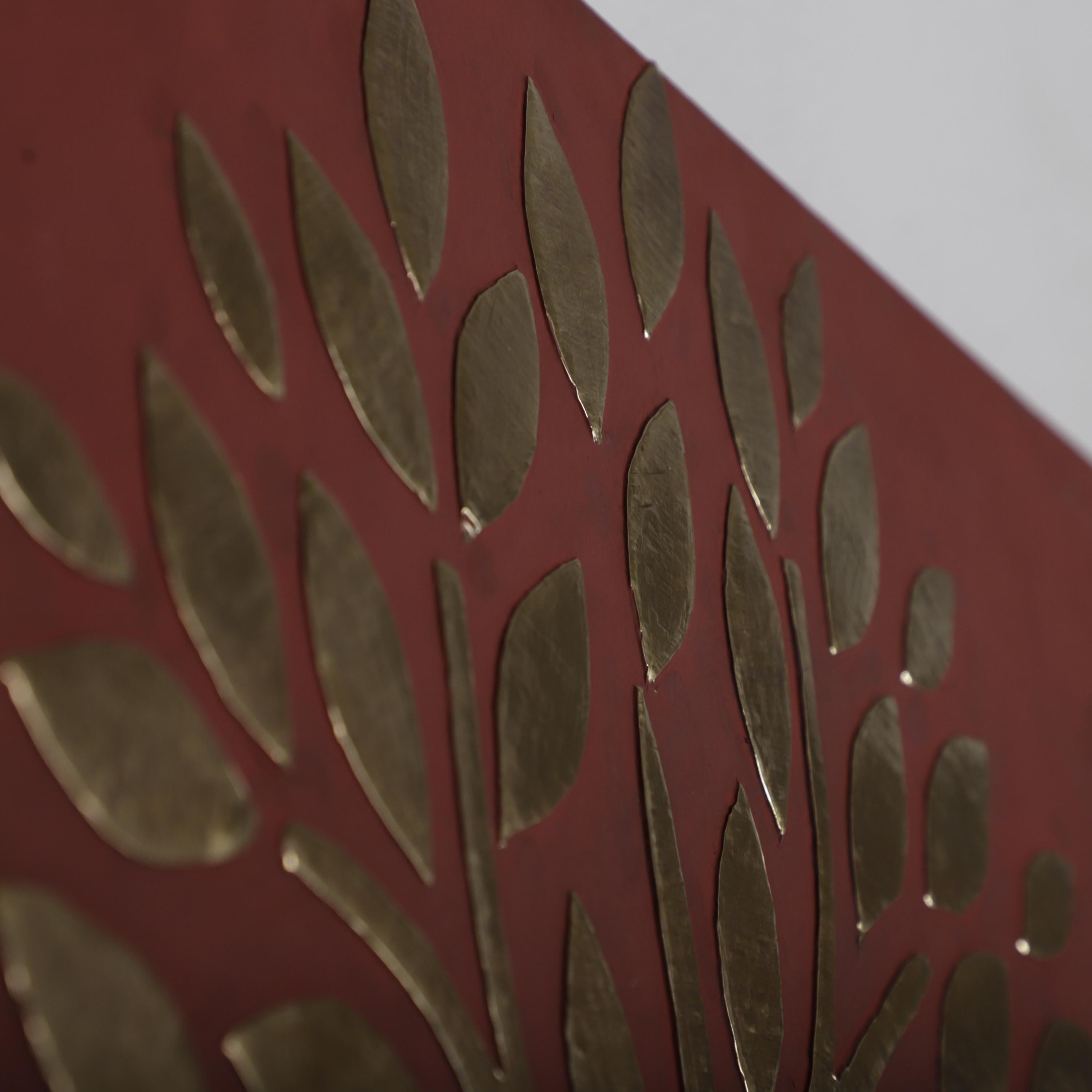 a close-up view of a red surface with a repeating pattern of leaf-shaped objects in varying shades of brown.