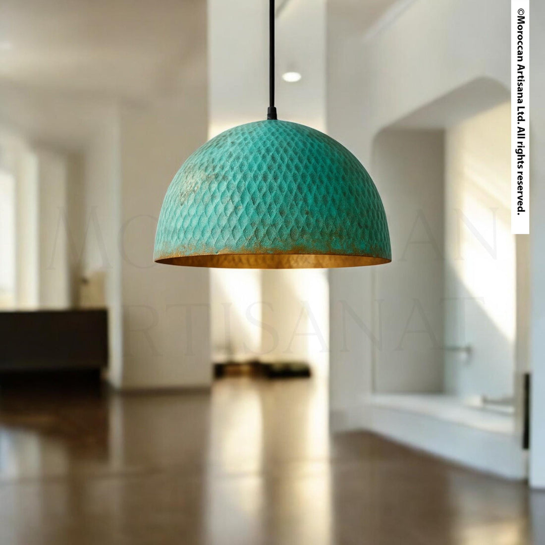 A turquoise pendant light hangs from the ceiling in a bright, white room with a wooden floor.