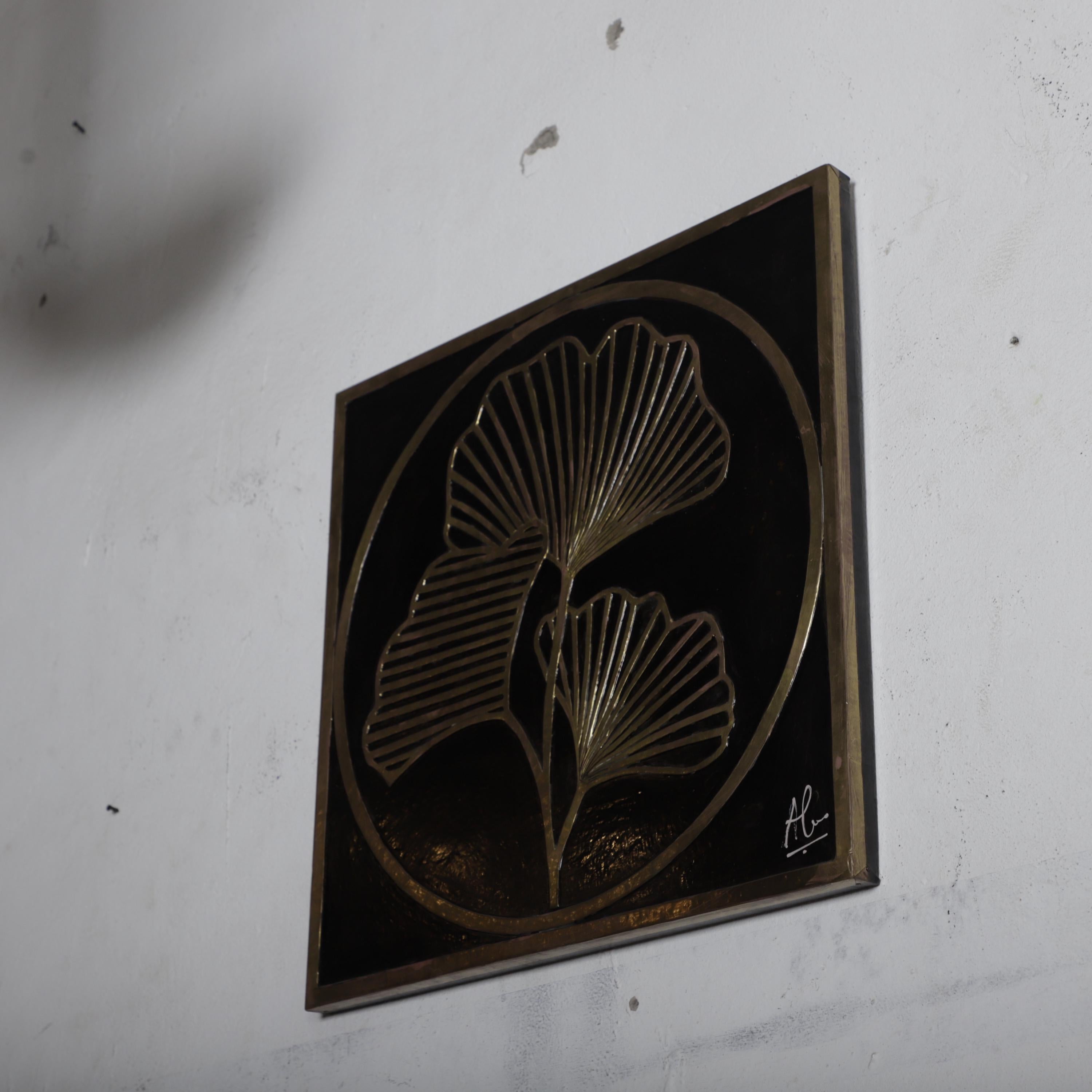 a decorative metal artwork with a stylized leaf design on a white wall.