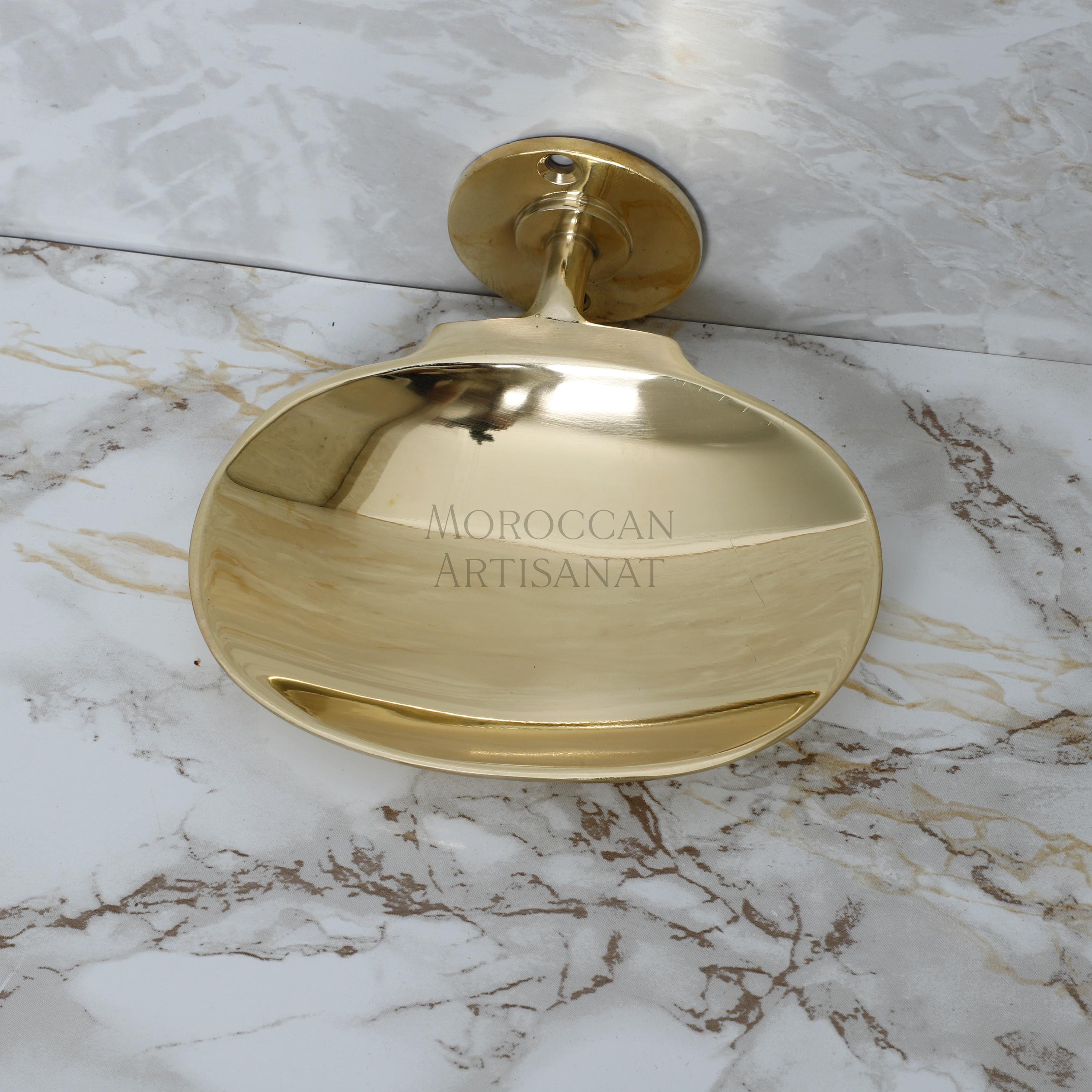a gold toilet paper dispenser on a marble floor
