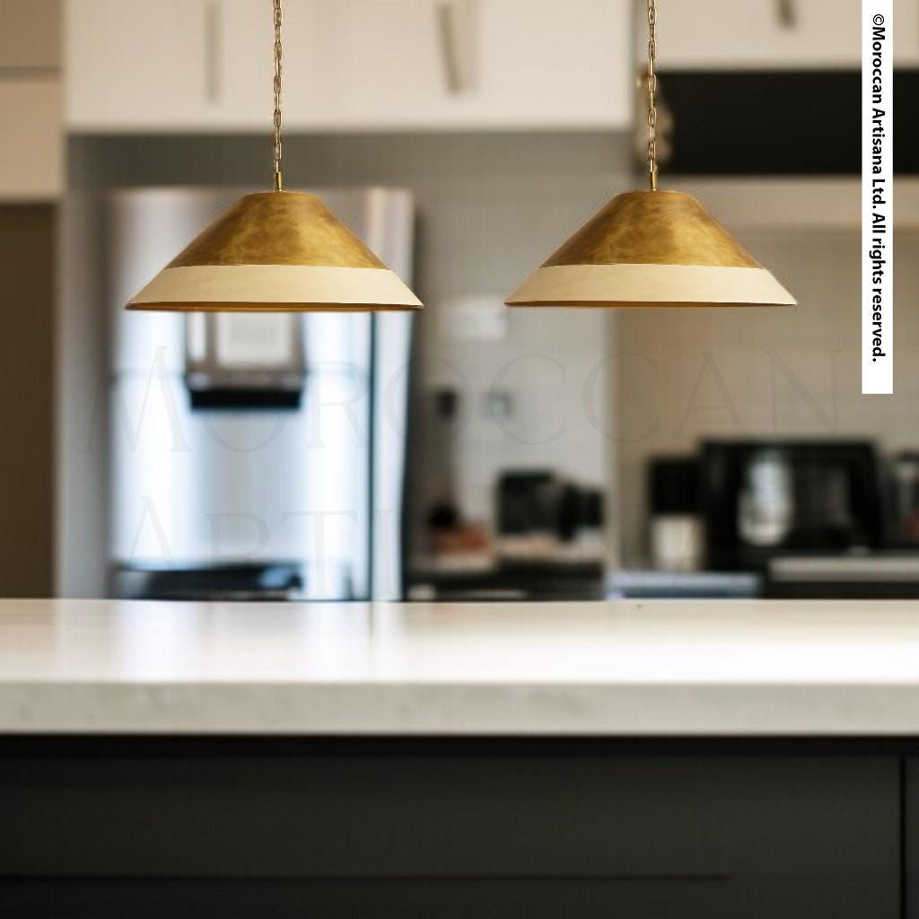 two pendant lights hanging from the ceiling in a kitchen setting.