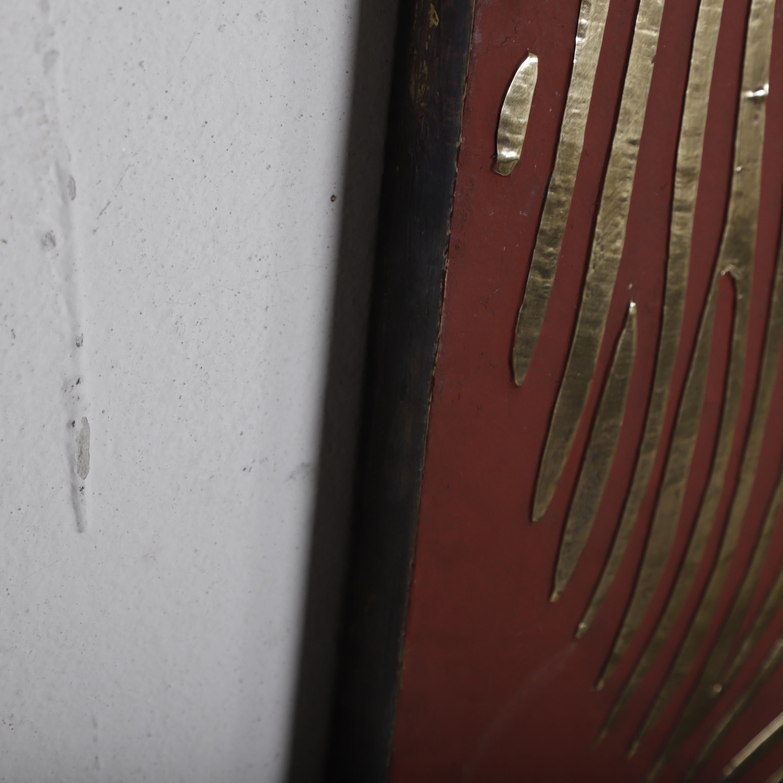 a close-up view of a red surface with a gold pattern, and a white wall on the left side.
