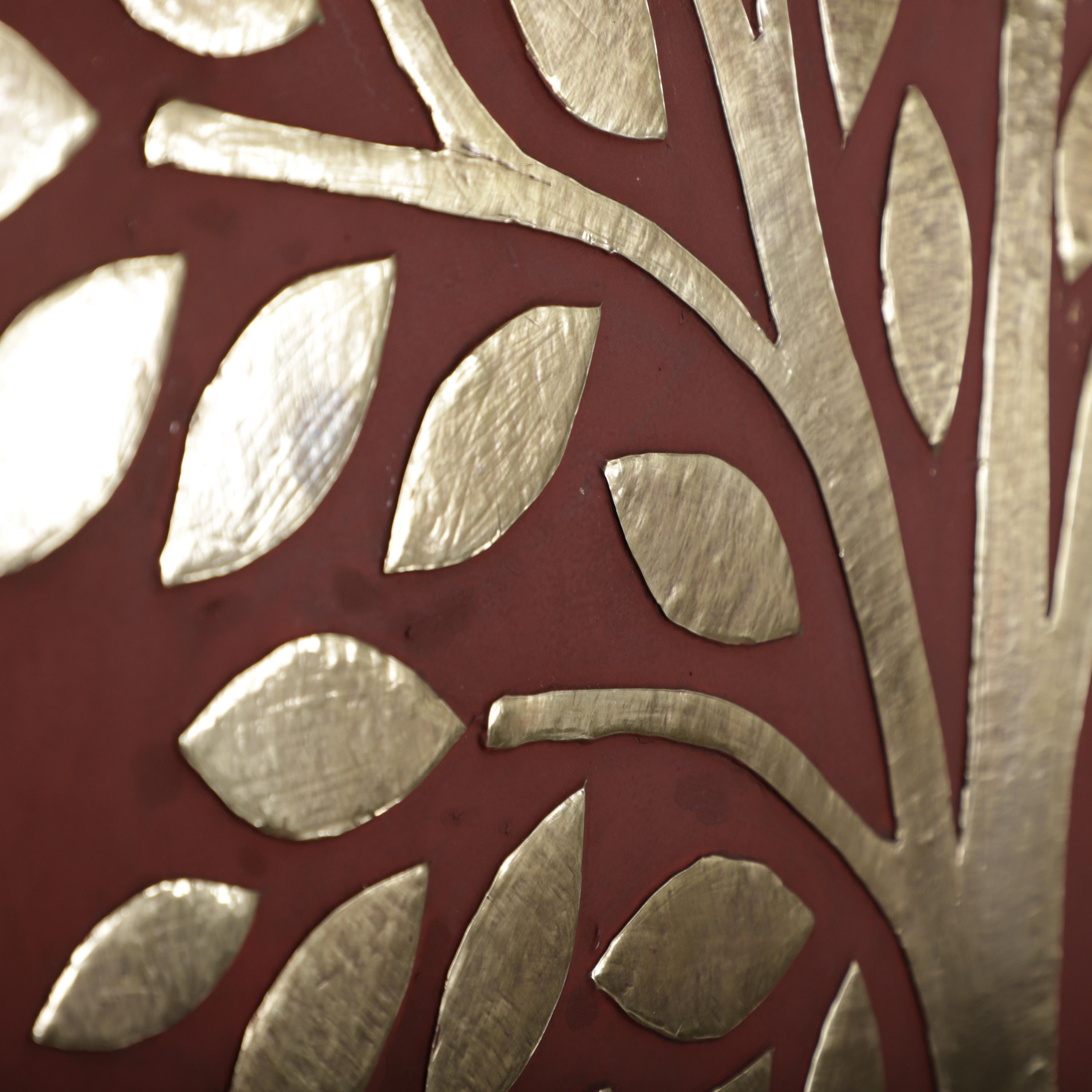 a close-up view of a red surface with a repeating pattern of metallic leaf-like shapes, creating a visually striking and intricate design.