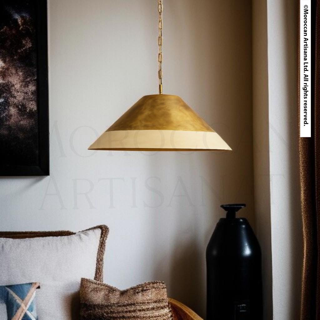 a modern living room with a gold pendant lamp hanging from the ceiling, a black vase on a side table, and a beige pillow on a couch.