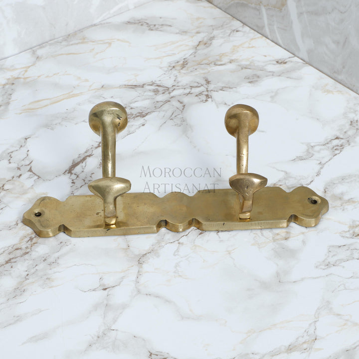 a pair of brass hooks on a marble counter