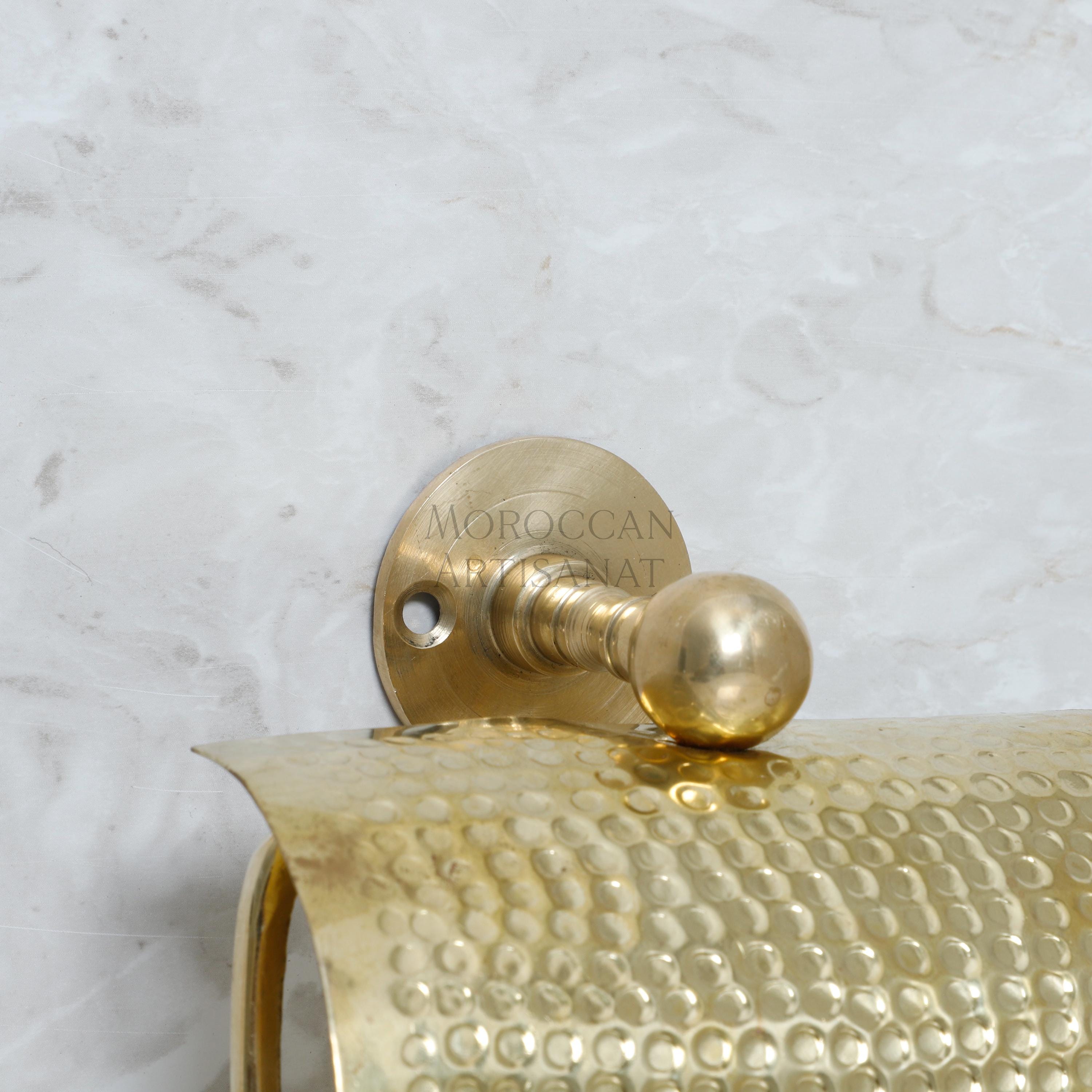 a close up of a gold toilet paper holder