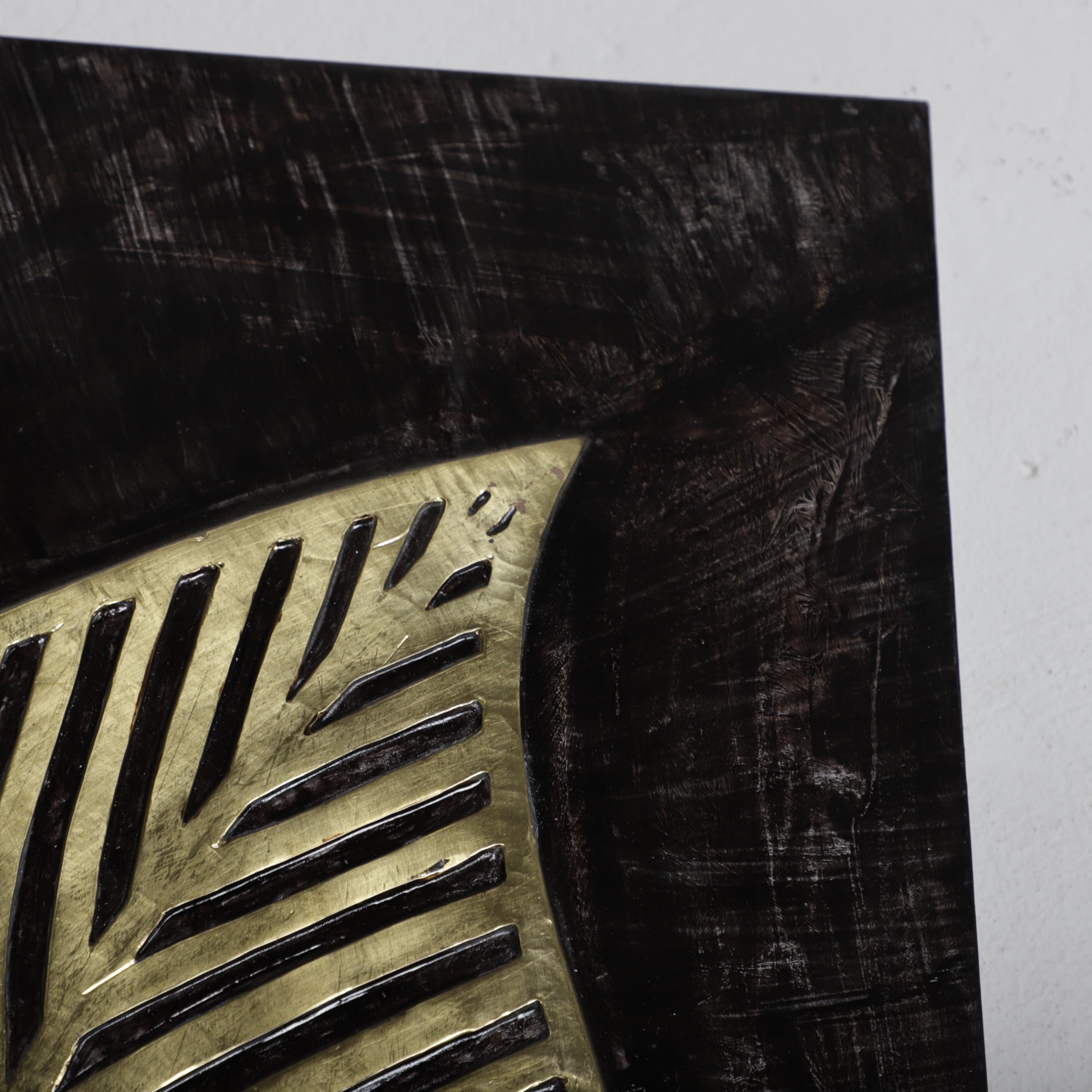 a close-up view of a black and gold metallic surface, possibly a piece of artwork or a decorative element.