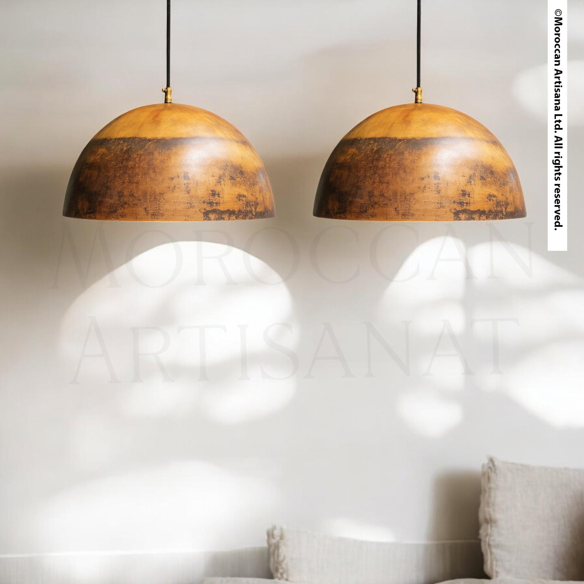 two hanging pendant lights with a rustic, aged appearance, suspended from the ceiling.