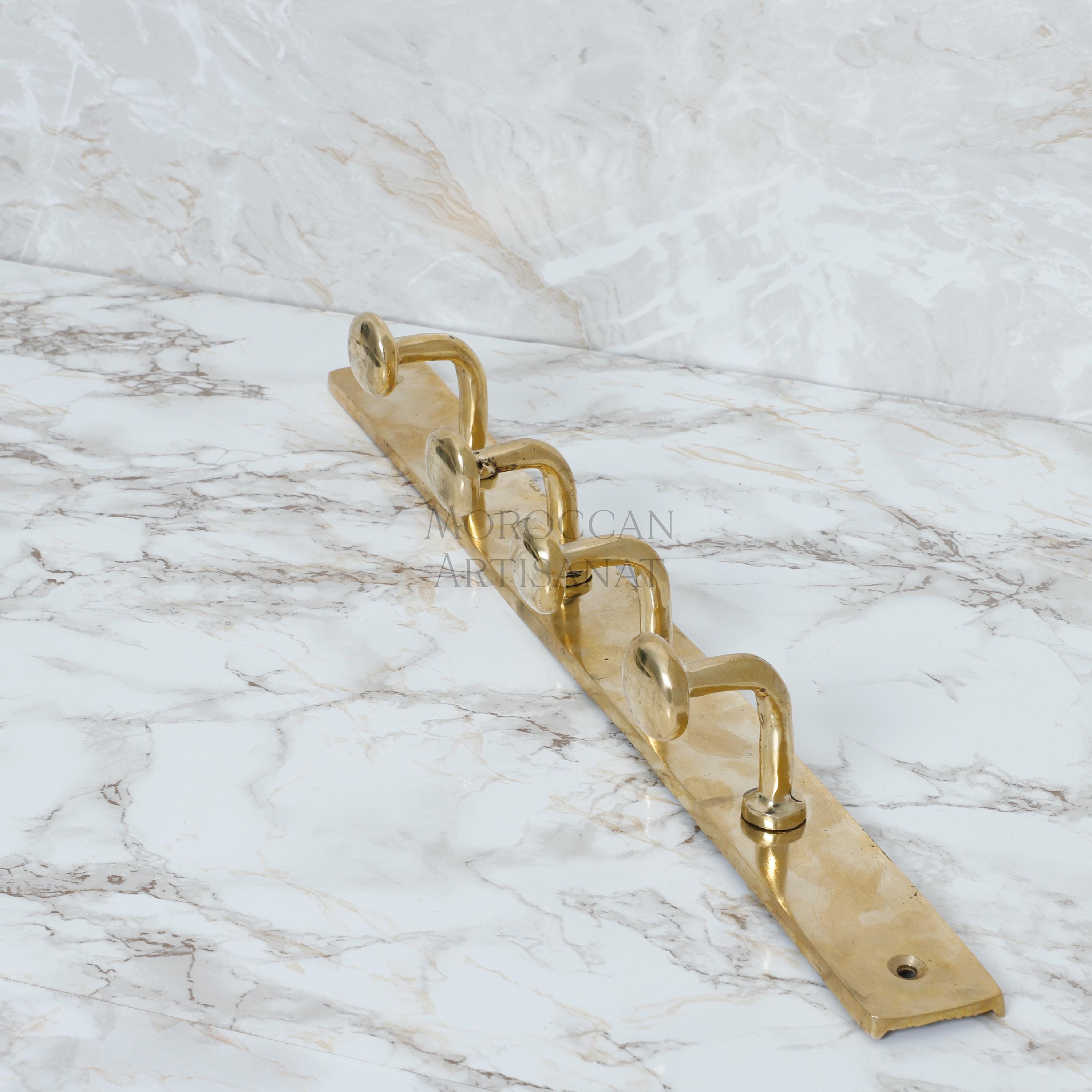 a golden metal hook on a marble surface