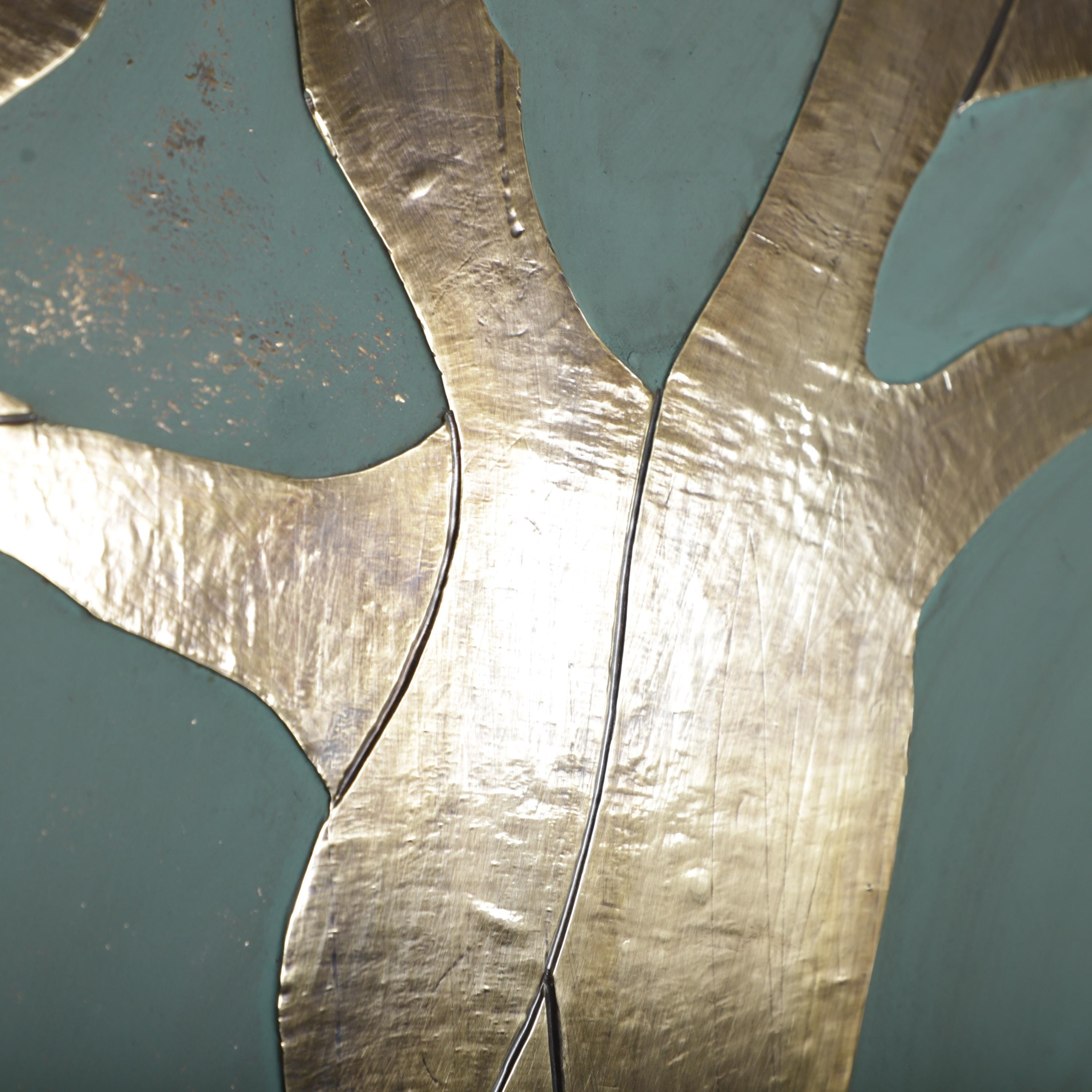 The image is a close-up of a metallic surface with a textured, shiny appearance. The surface appears to be made of a shiny material, possibly gold or silver, and has a textured pattern. The image does not contain any discernible objects or actions, and there are no specific actions or movements depicted. The image does not contain any text or other objects, and the overall composition is simple and minimalistic.