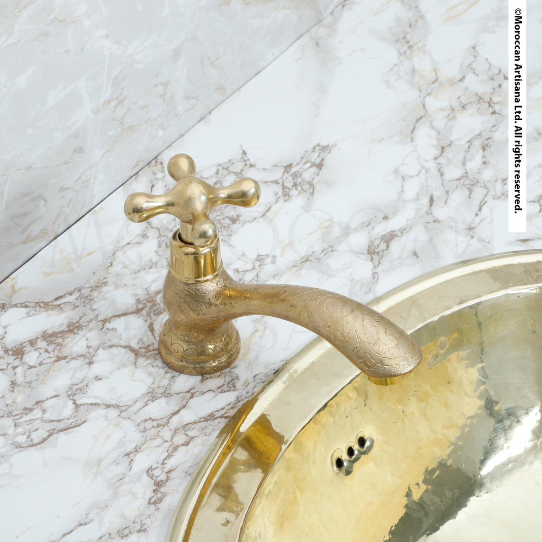 a gold-colored faucet with a decorative handle, situated above a round, gold-colored sink.