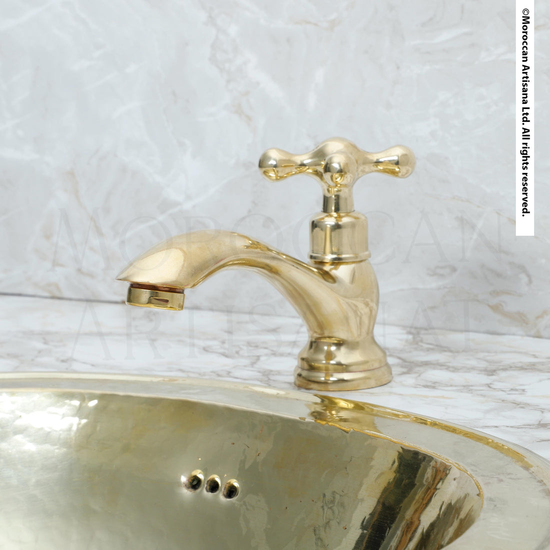 A gold-colored faucet with a curved spout is positioned above a round, reflective sink in the image.