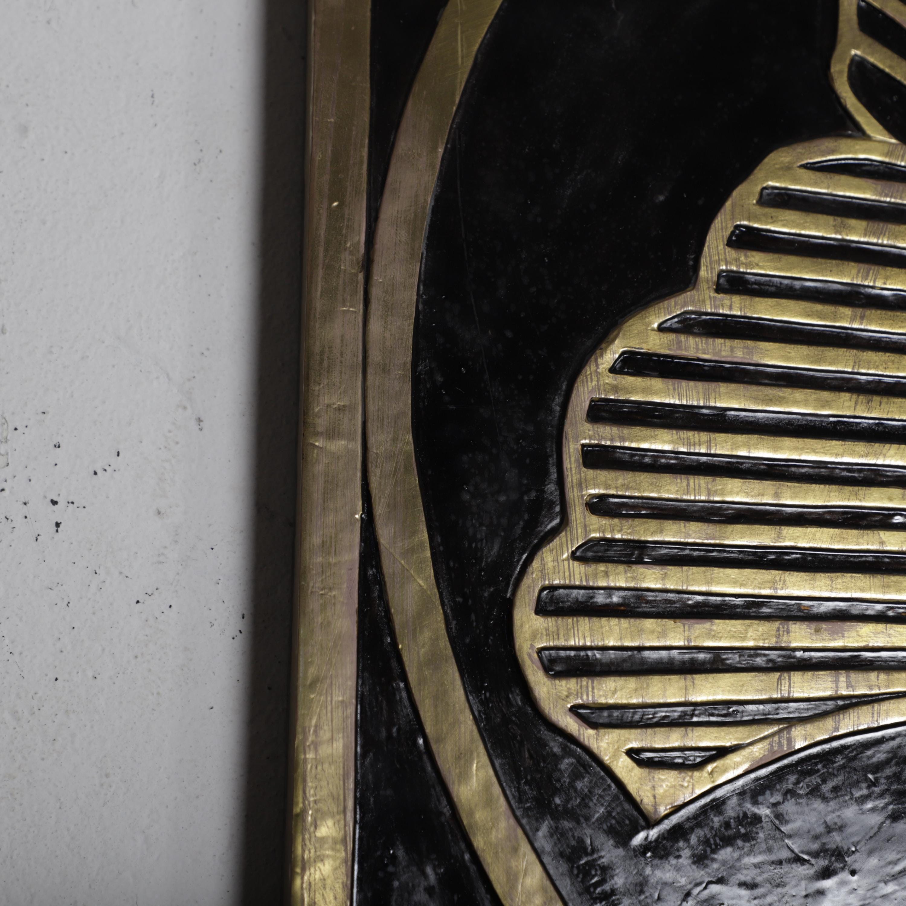 a close-up view of a black and gold decorative surface, possibly a wall or a piece of artwork. The surface has a repeating pattern of black and gold lines and shapes, creating a visually striking and intricate design.