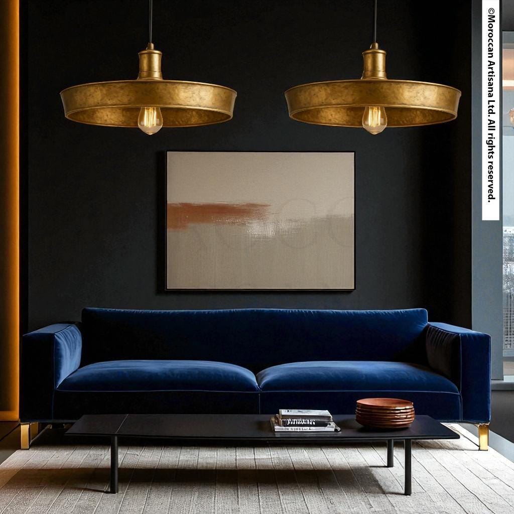 a modern living room with a blue velvet sofa, a black coffee table, and two gold pendant lights hanging above the sofa. The walls are painted black, and there is a large abstract painting hanging above the sofa.