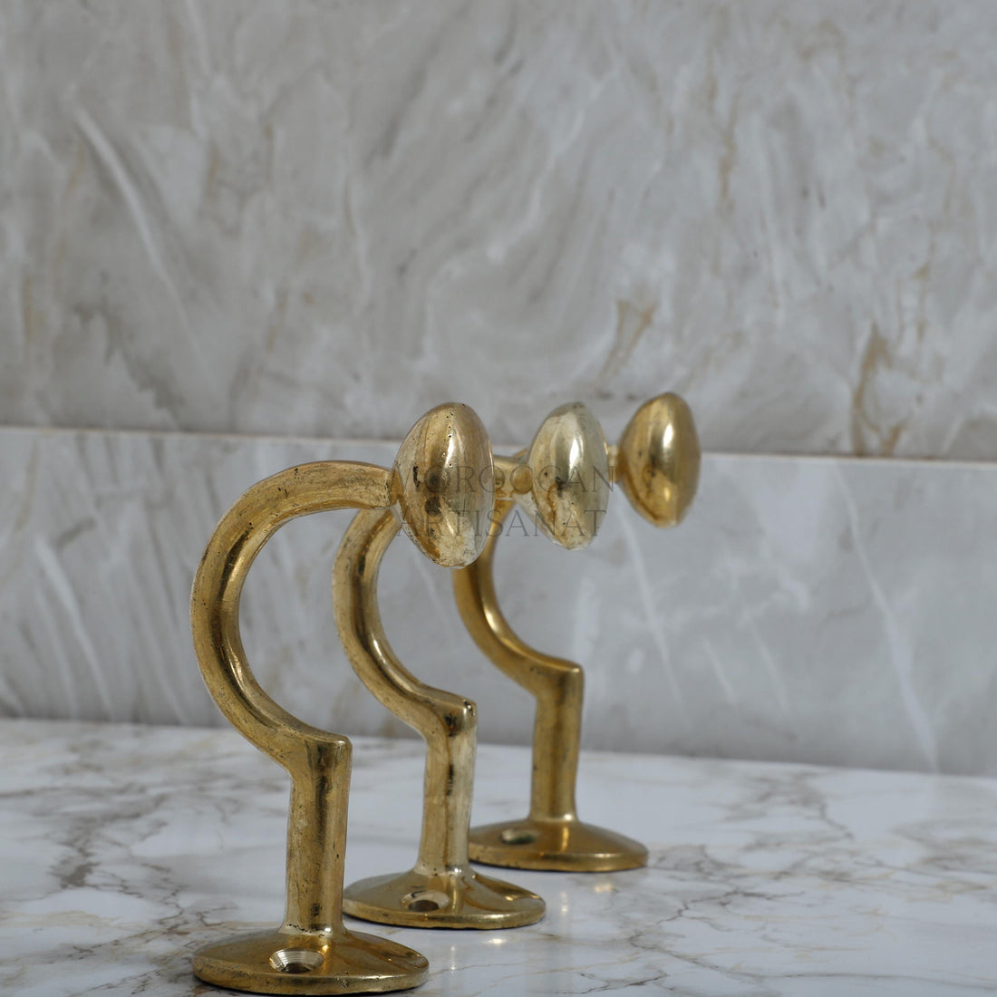 a pair of golden metal candlesticks on a marble table
