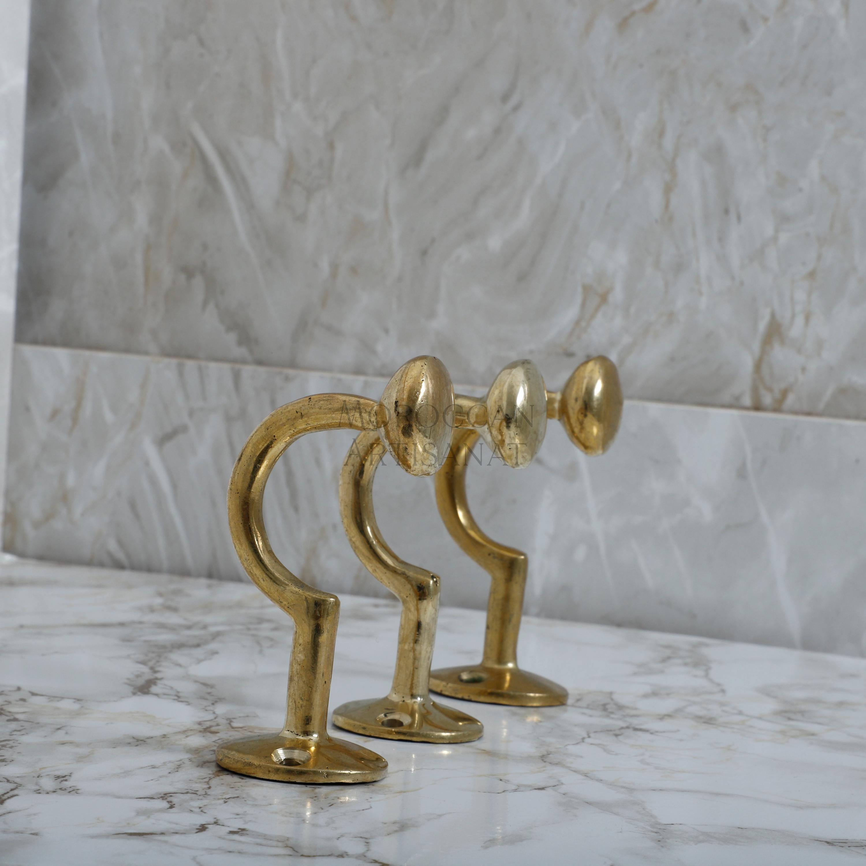 a pair of brass candlesticks on a marble counter