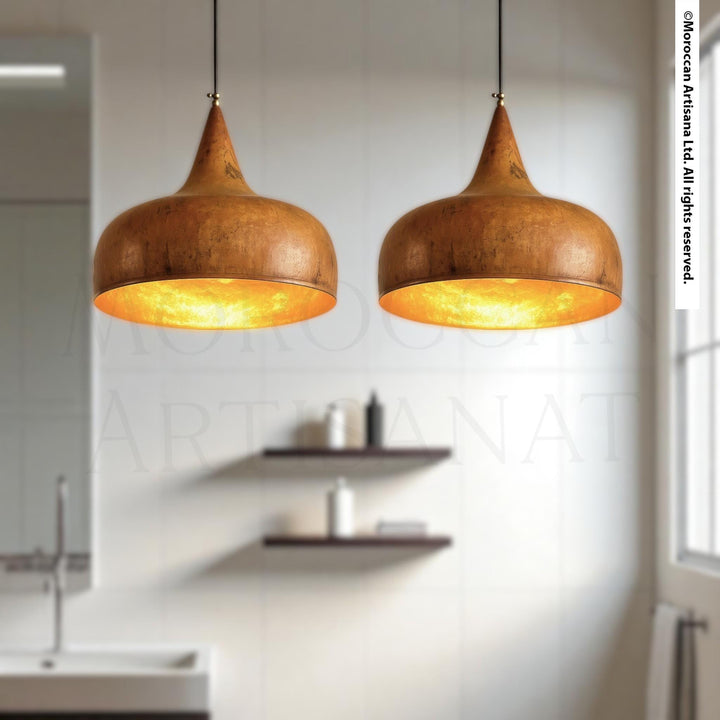 two pendant lights hanging from the ceiling in a modern bathroom, with a shelf below them and a window in the background.