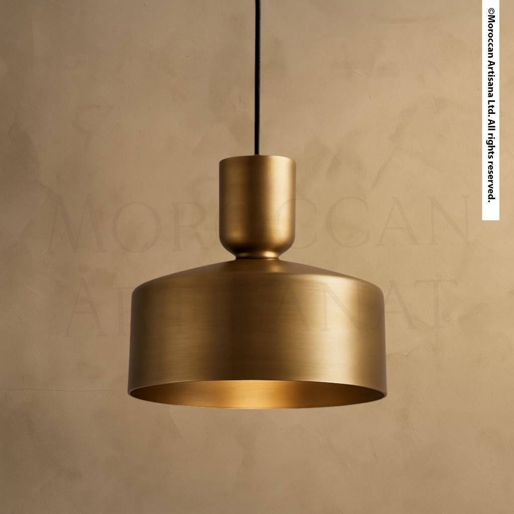 A gold-colored pendant light fixture hangs from the ceiling against a beige wall.