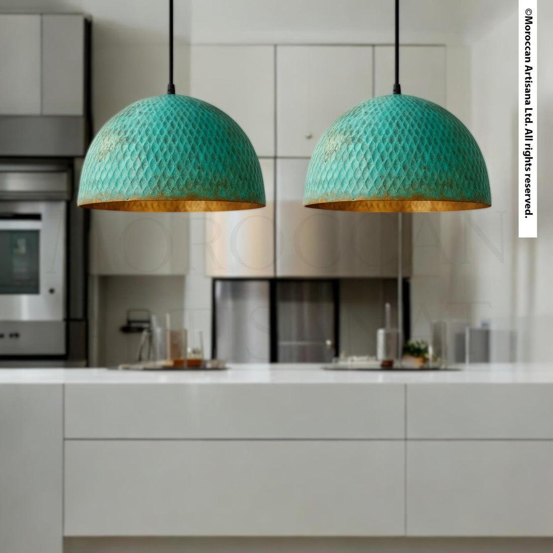 two green pendant lights hanging above a white kitchen counter.