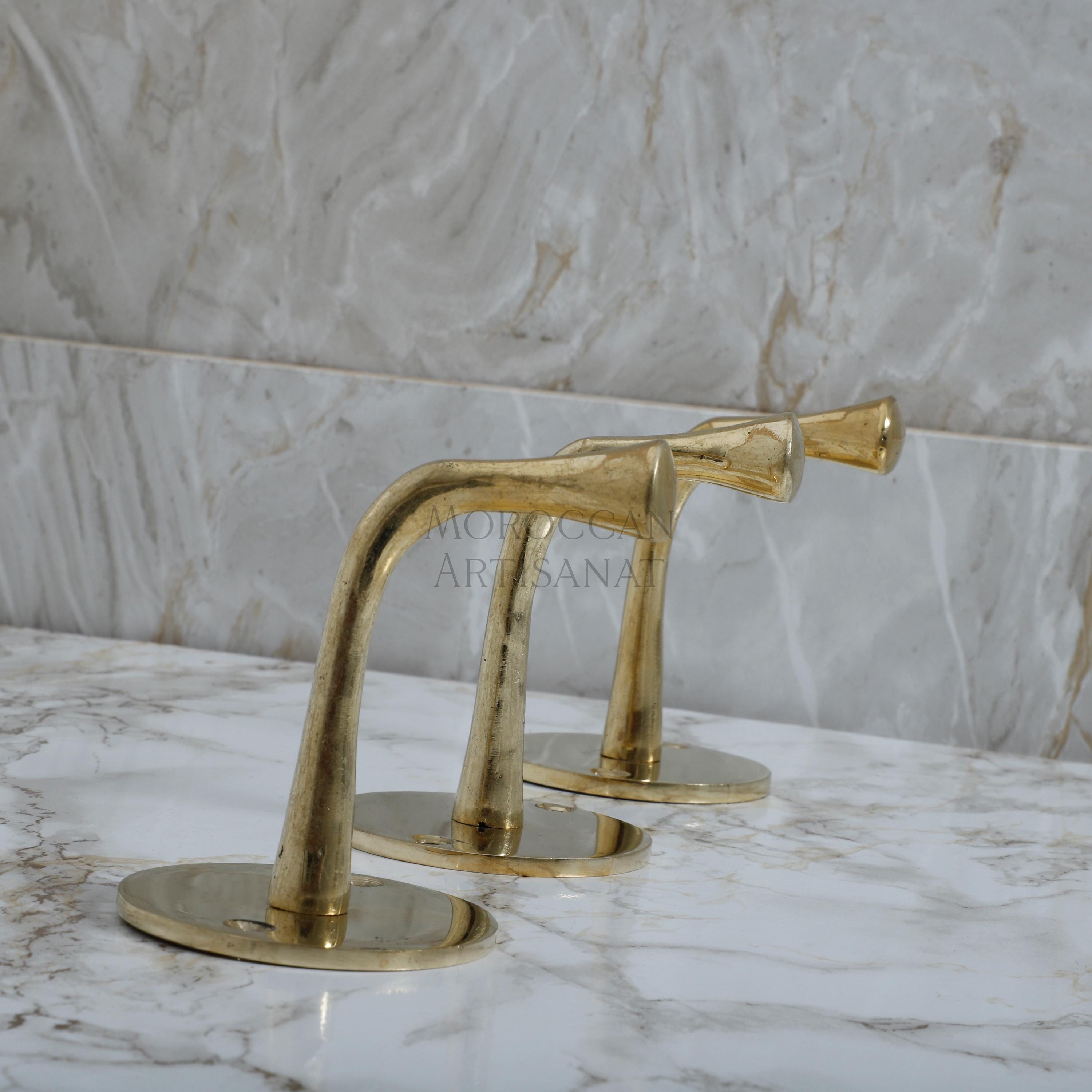a pair of brass faucets on a marble counter