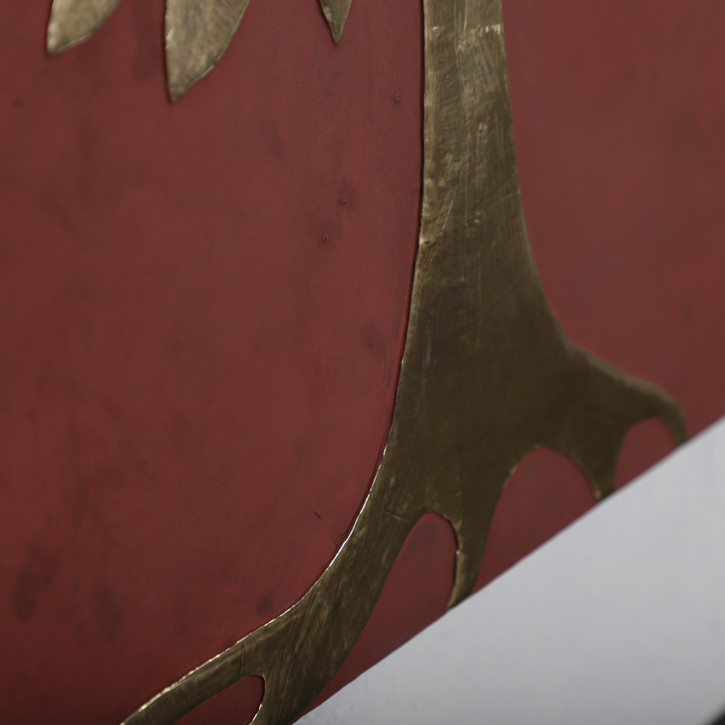 a close-up view of a metallic tree-like structure with a reddish-brown background.