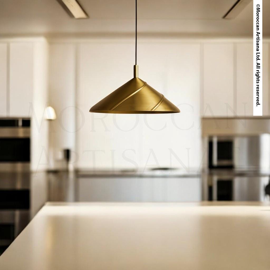 A modern kitchen with a gold pendant light hanging above a white countertop.