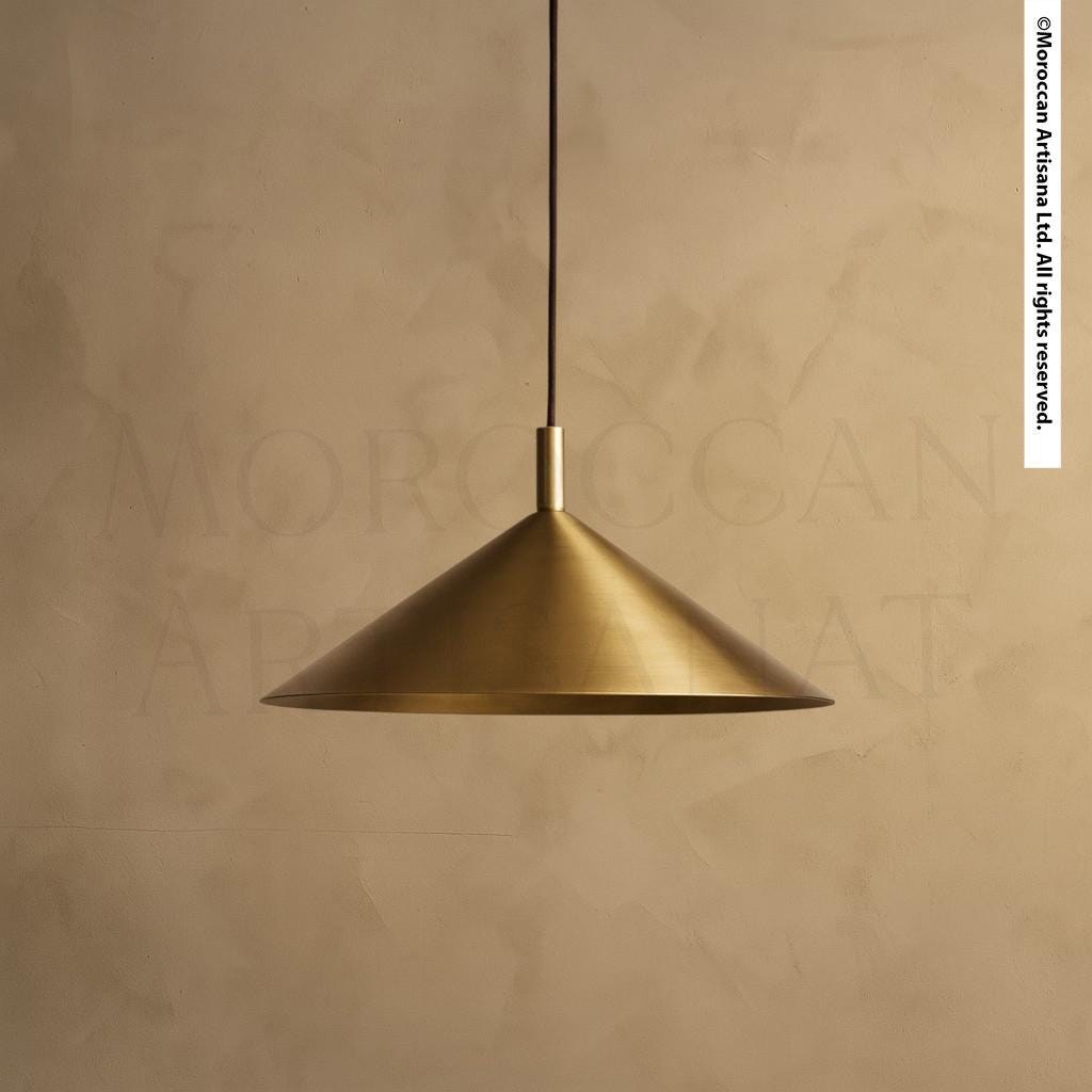 A gold-colored pendant light hangs from the ceiling against a beige wall.