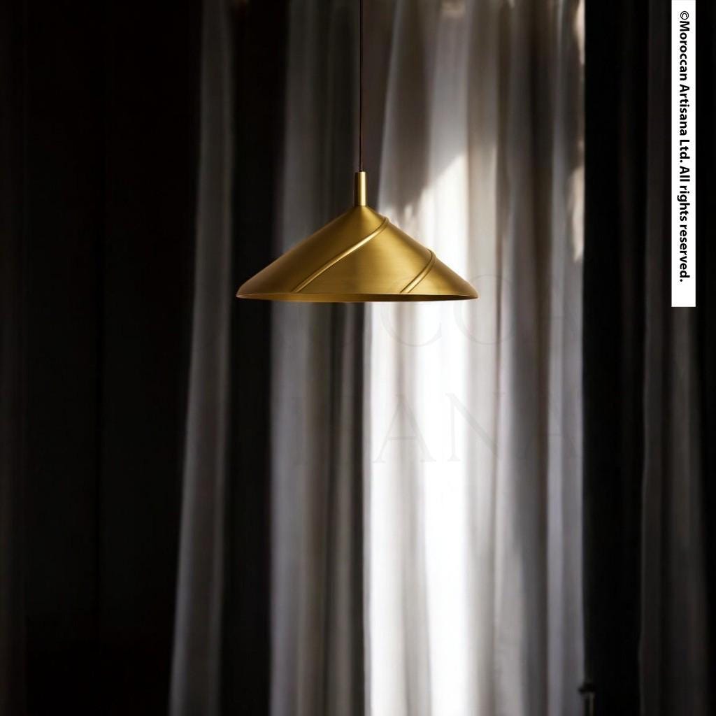 A gold pendant lamp hangs from the ceiling, casting a warm glow against a backdrop of white curtains.