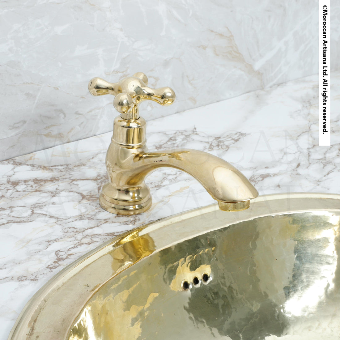 a gold-colored faucet and a gold-colored sink, both set against a marble countertop.