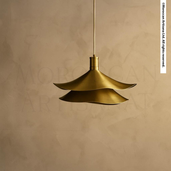 A gold-colored pendant light fixture hangs from the ceiling against a beige wall.