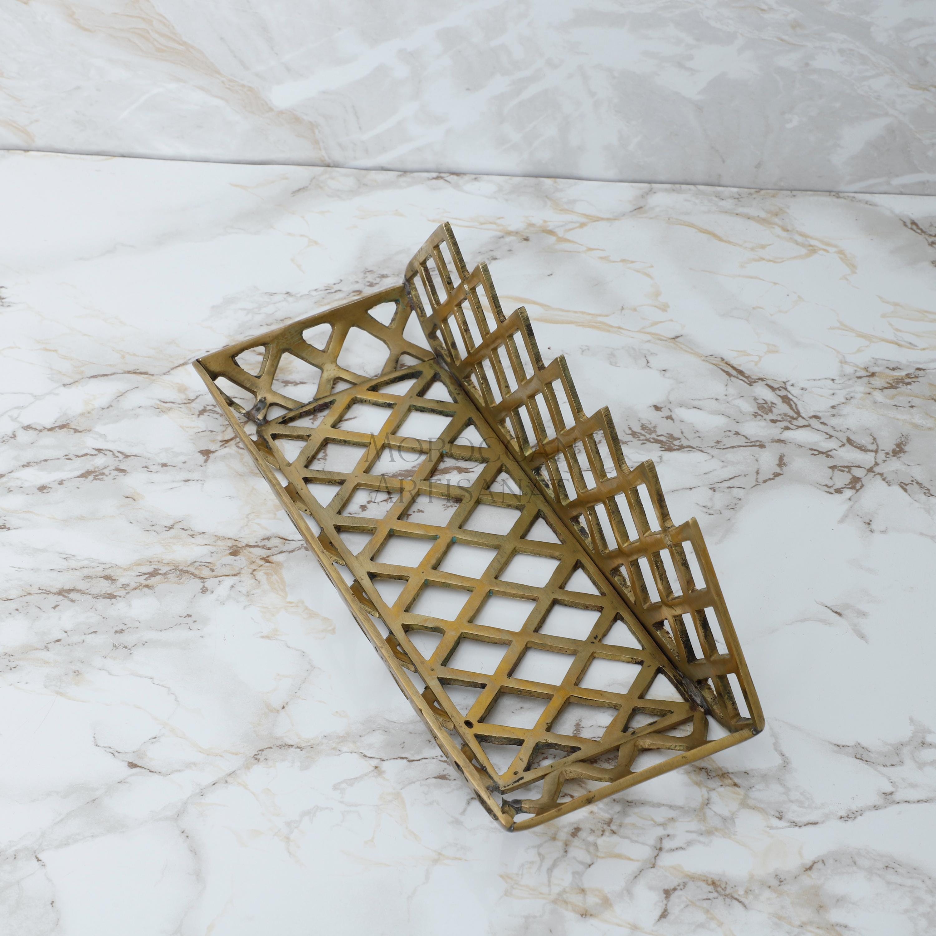 a pair of gold metal baskets sitting on a marble surface