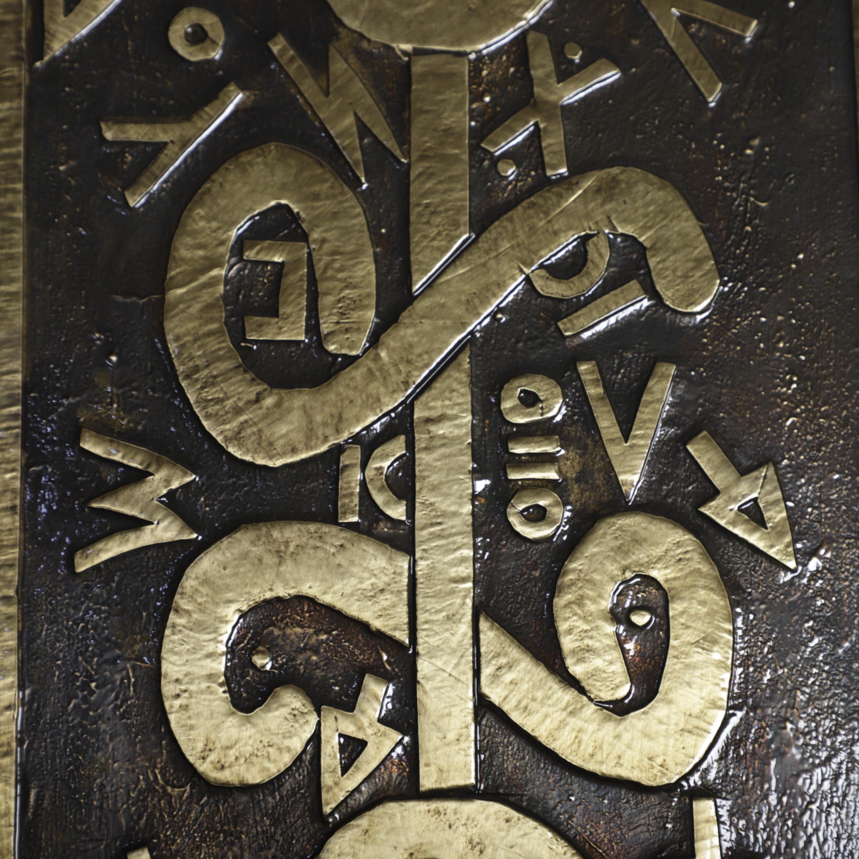 a close-up view of a textured surface with various shapes and symbols carved into it. The symbols appear to be in a foreign language, with some of them being stylized and others being more abstract. The image does not contain any text that is less than 500 characters, and it does not include any phrases like &#39;The image depicts&#39;, &#39;The image displays&#39;, &#39;The image shows&#39;, &#39;In the image&#39;, &#39;The image captures&#39;, or similar.