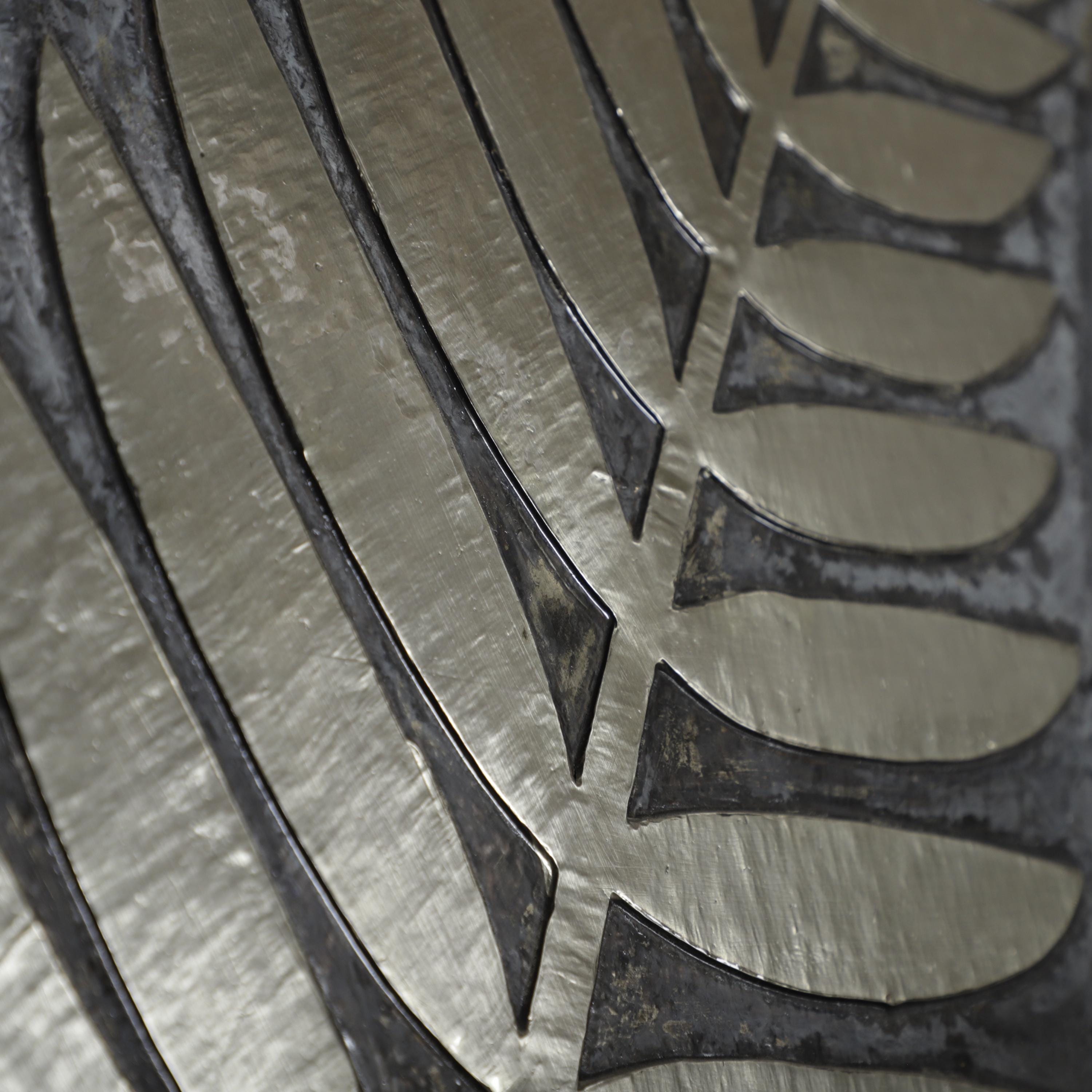 a close-up view of a metallic surface with a repeating pattern of curved lines and shapes, creating a visually striking and intricate design.