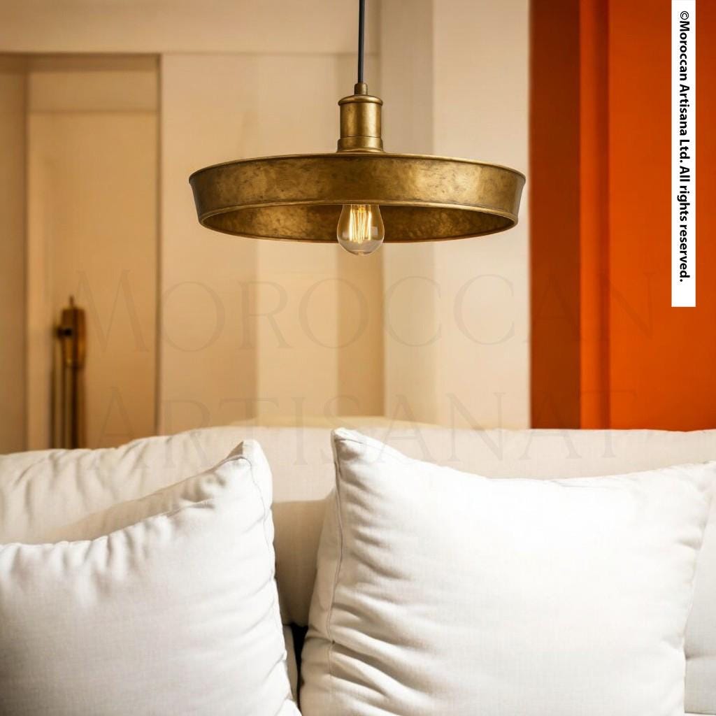 a modern living room with a white sofa and a gold pendant light hanging above it.